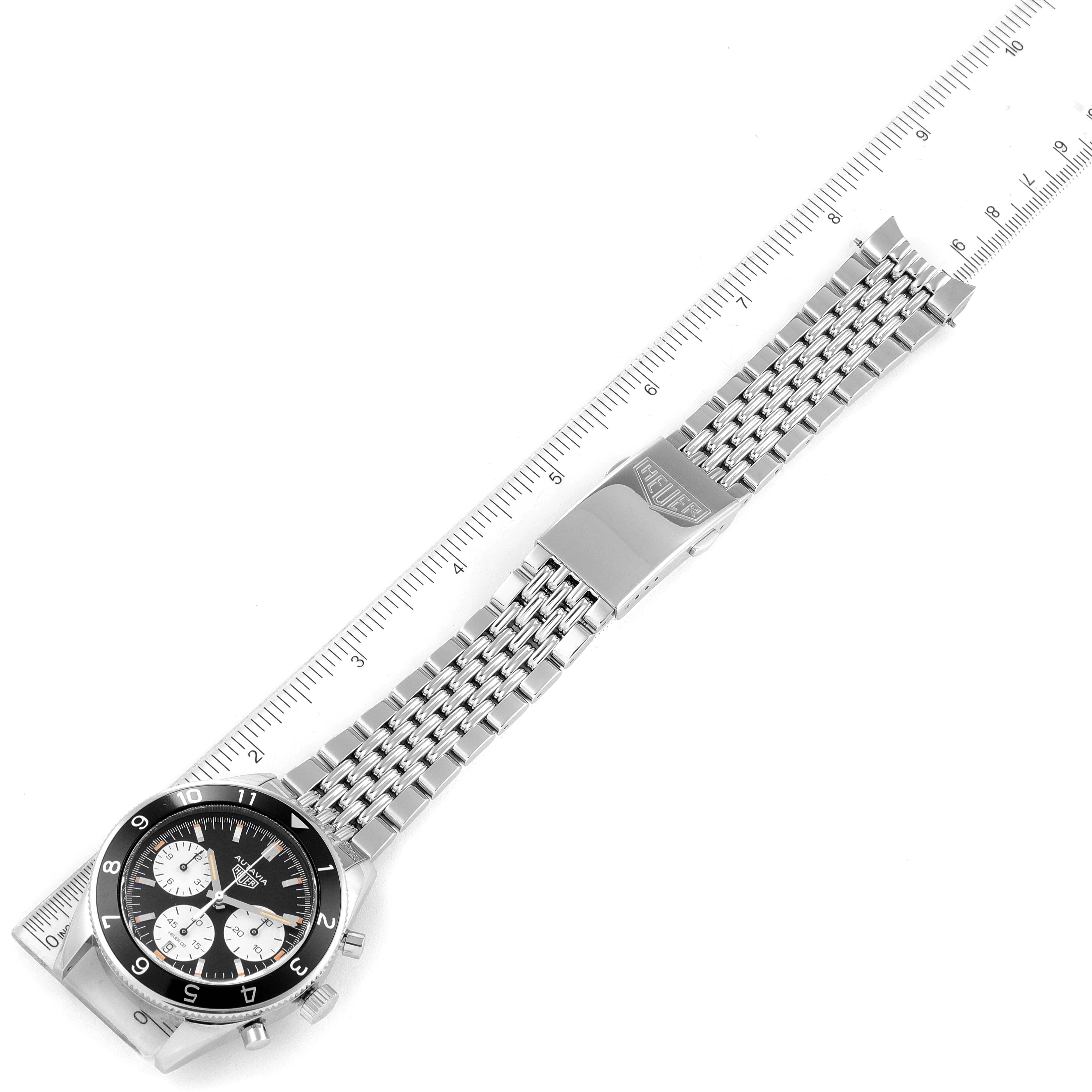 The image shows a Tag Heuer Autavia CBE2110.BA0687 Men's Stainless Steel Black Dial CBE2110.BA0687 Men's Stainless Steel Black Dial watch laid flat, highlighting its dial, bezel, and metal bracelet with a ruler for scale.