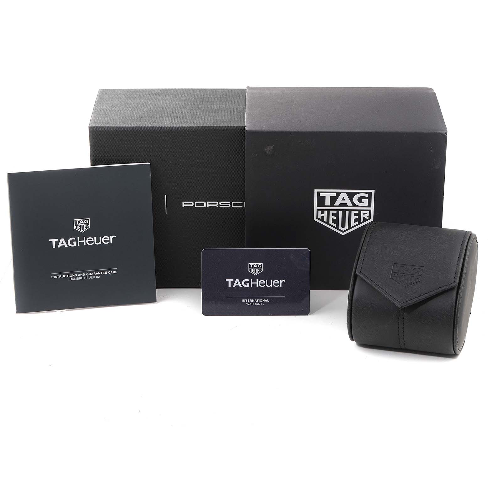 The image shows the packaging box, instruction booklet, warranty card, and a carry-case for a Tag Heuer Carrera watch.