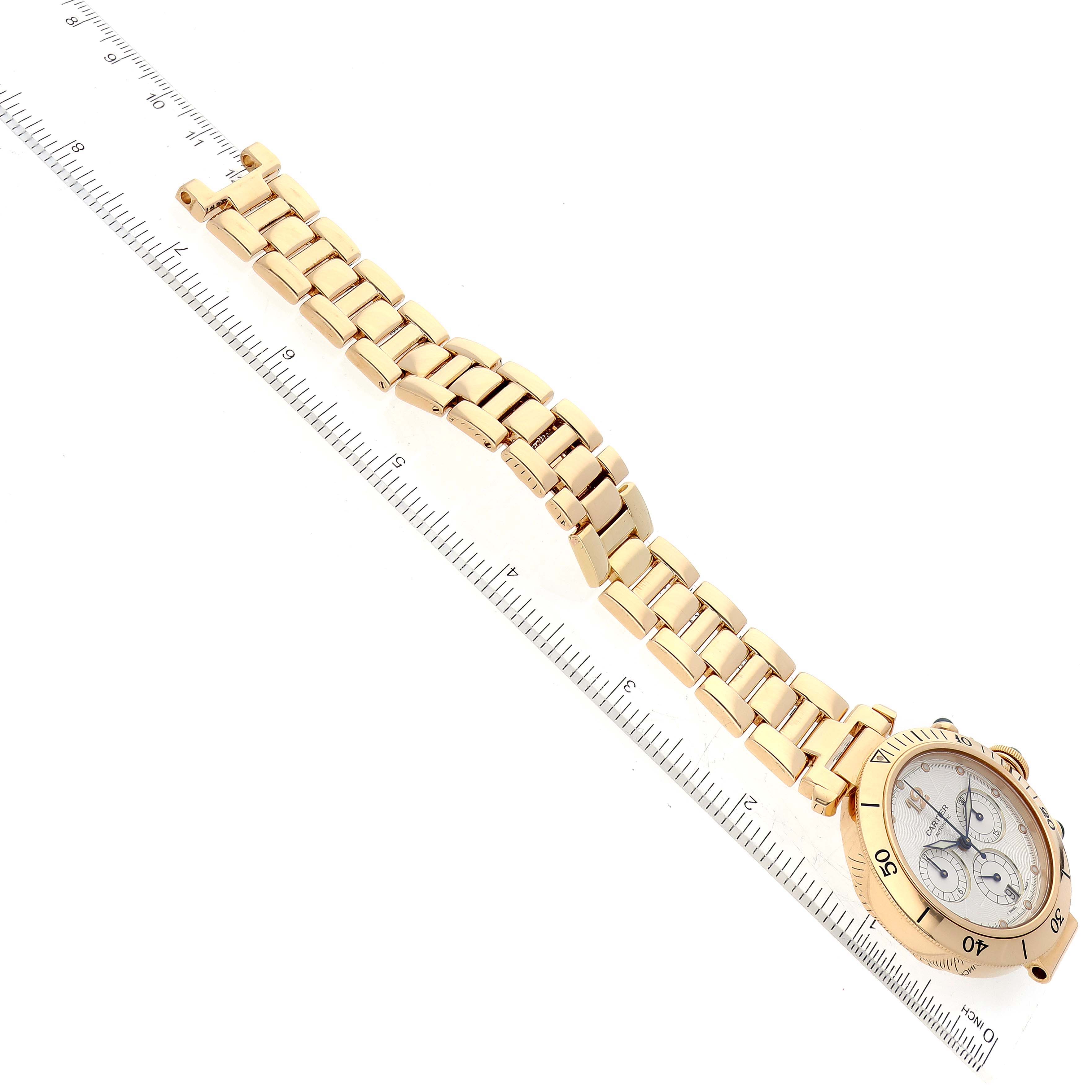 The image displays the Cartier Pasha 2111 Men's Yellow Gold Silver Dial 2111 Men's Yellow Gold Silver Dial watch, including the face, bezel, and metal bracelet, placed alongside a ruler for scale.