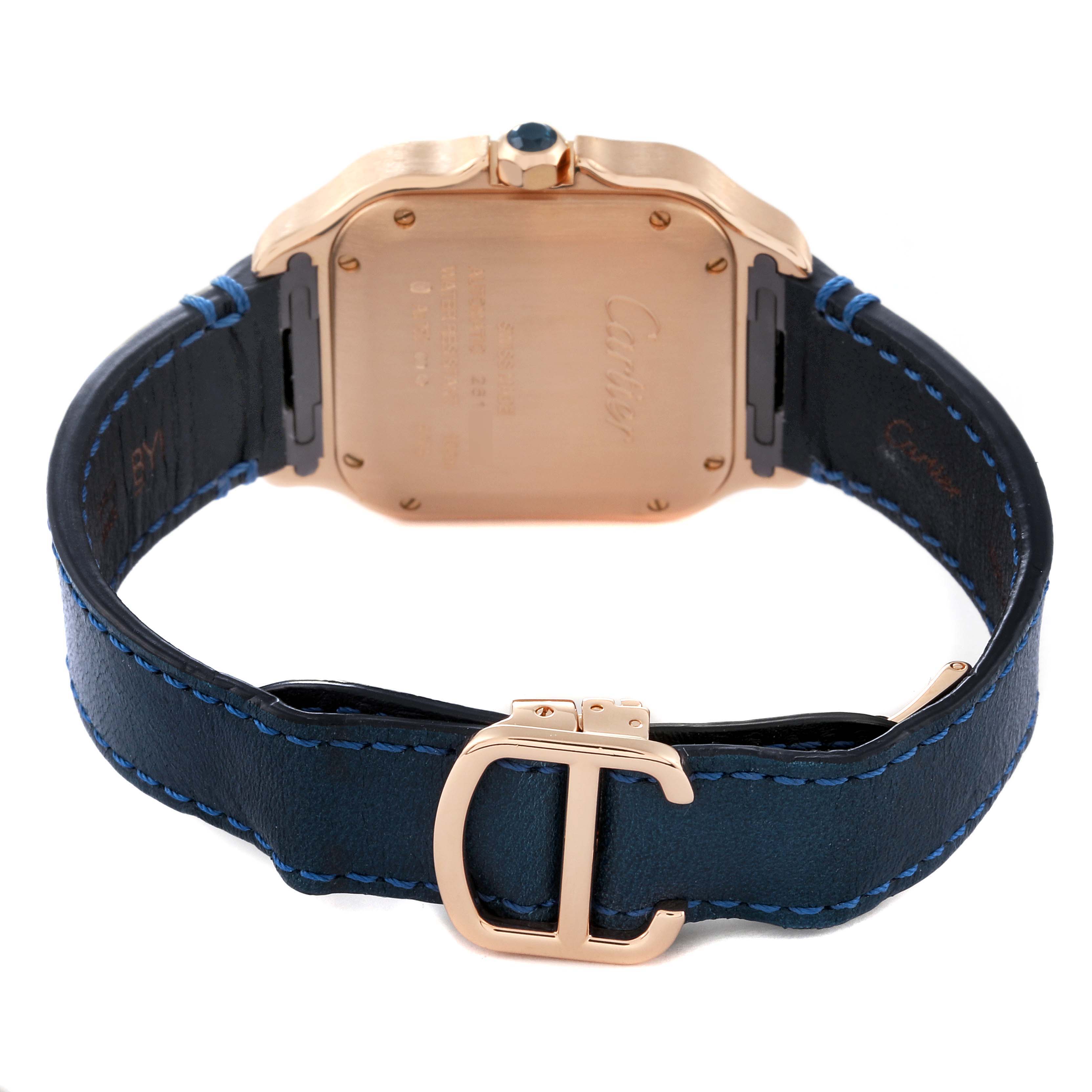 This image shows the back of a Santos model by Cartier, highlighting the case and blue leather strap with a distinct "C" buckle.