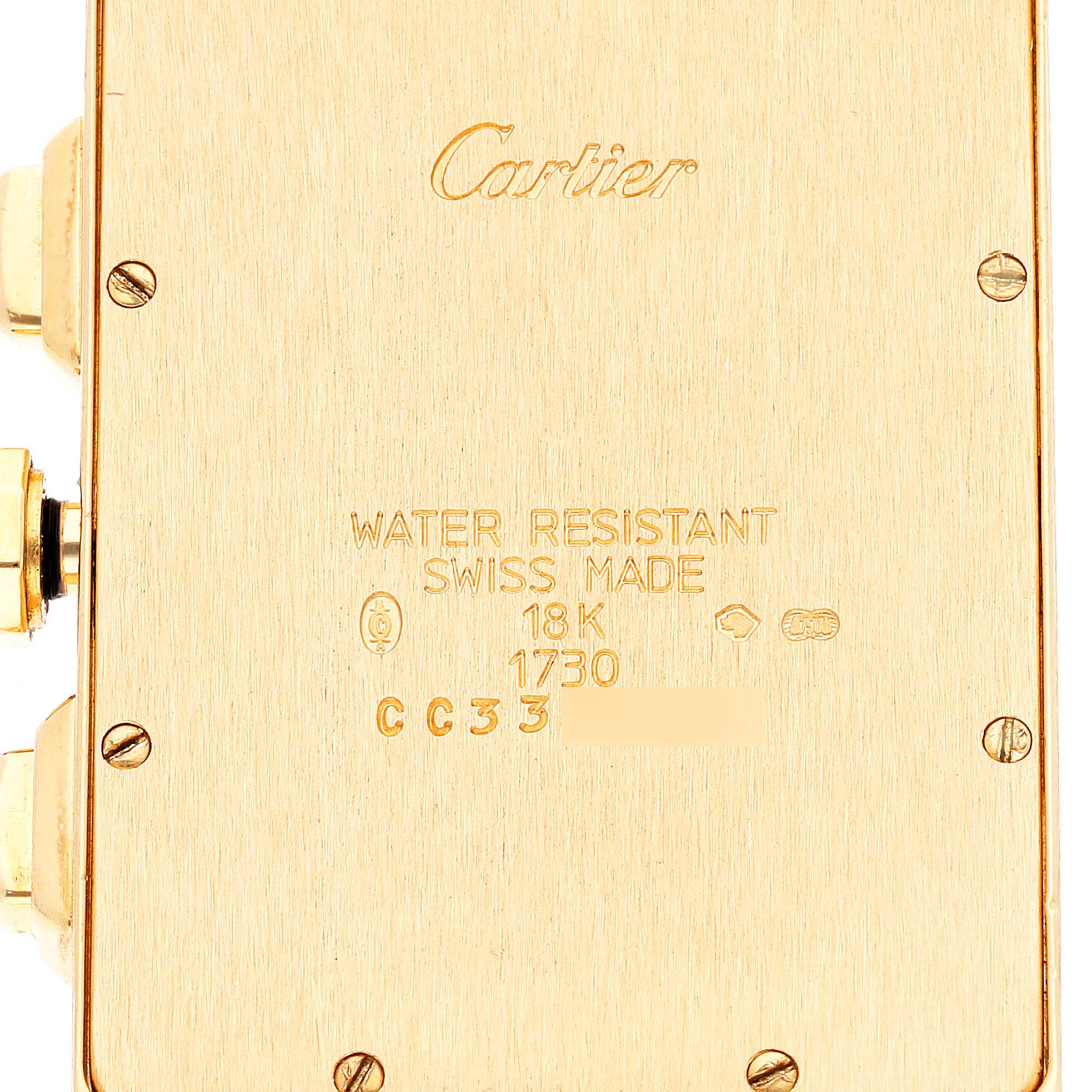 This image shows the back casing of a Cartier Tank Americaine W2601156 Men's Yellow Gold Silver Dial W2601156 Men's Yellow Gold Silver Dial watch, engraved with branding and specifications.