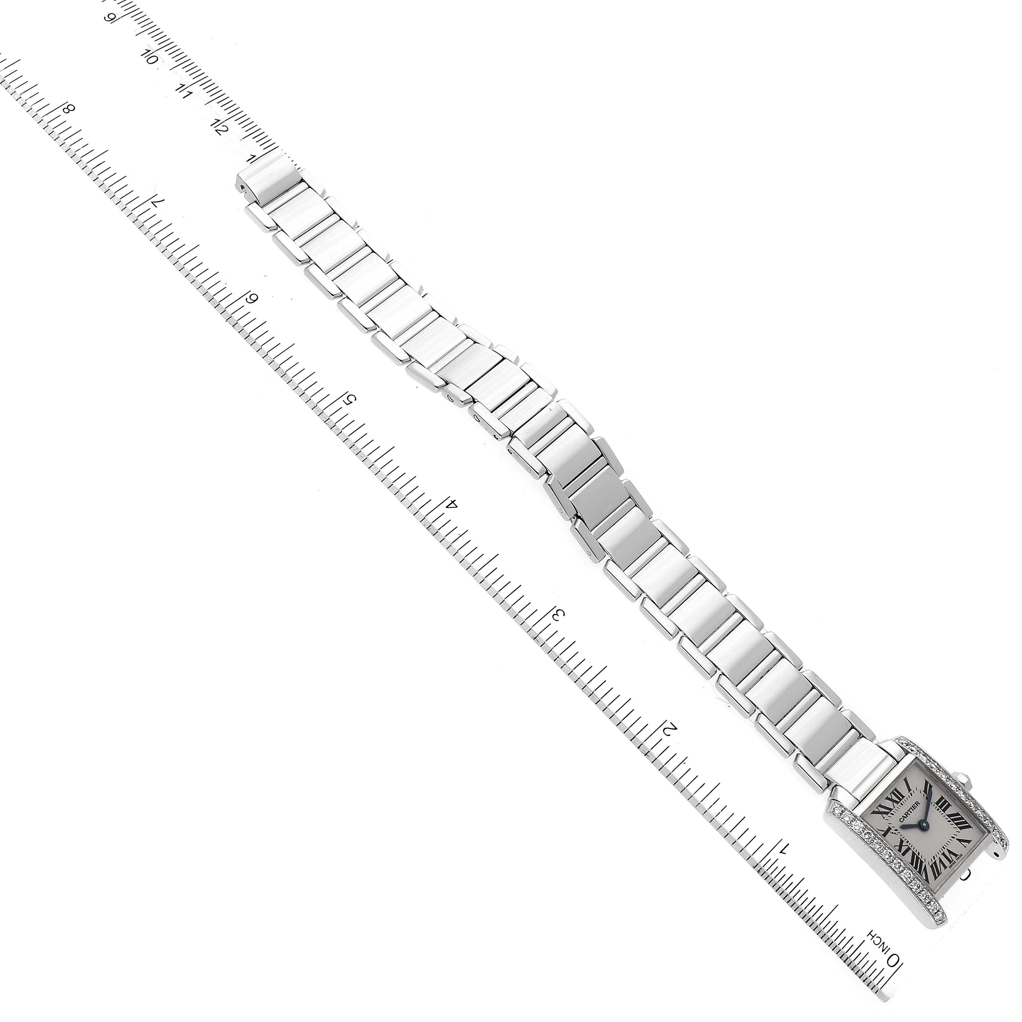 The Cartier Tank Française watch is shown from a top-down angle with a focus on the entire bracelet and face, along with a ruler for scale.