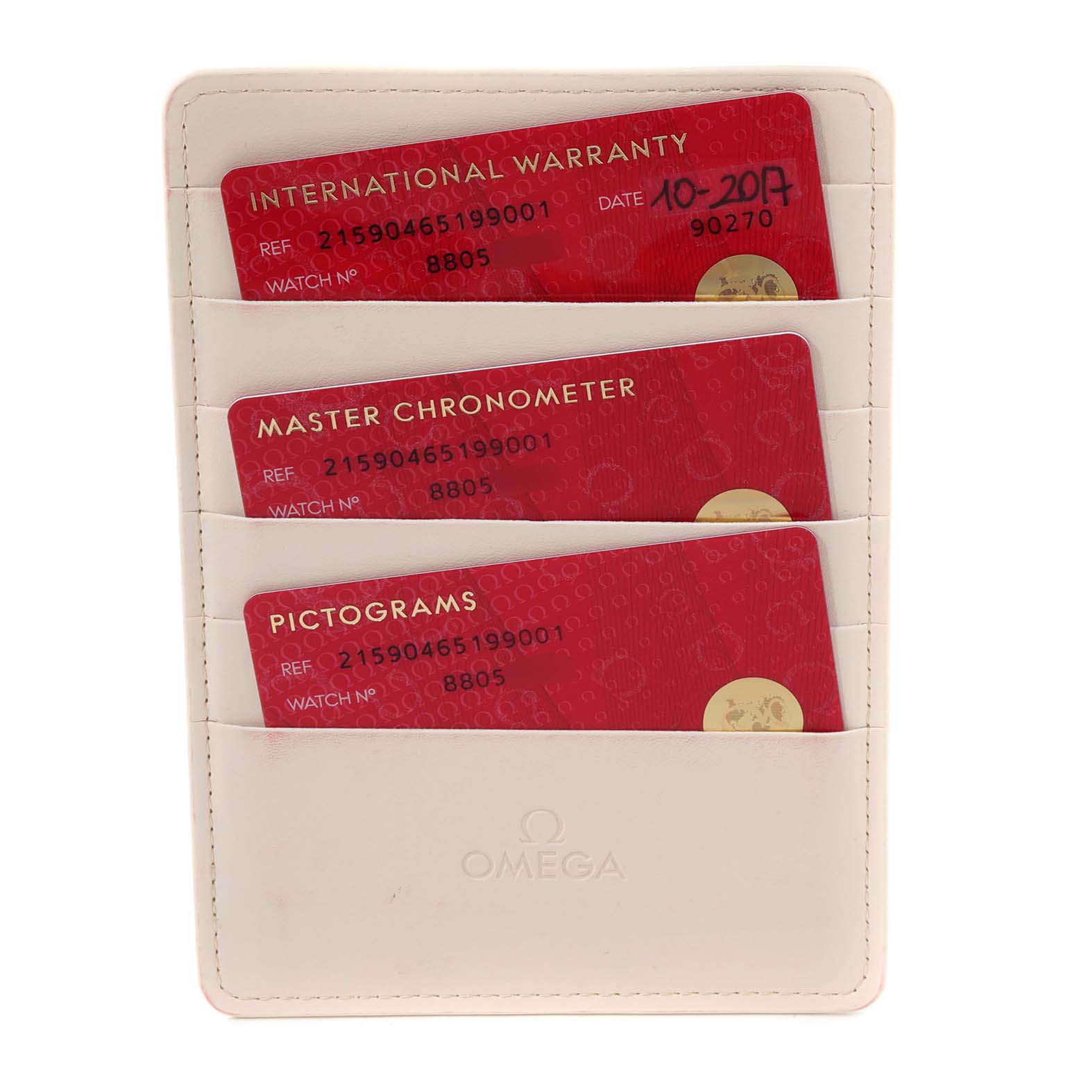 The image shows three red cards, including International Warranty, Master Chronometer, and Pictograms, in a white Omega cardholder.