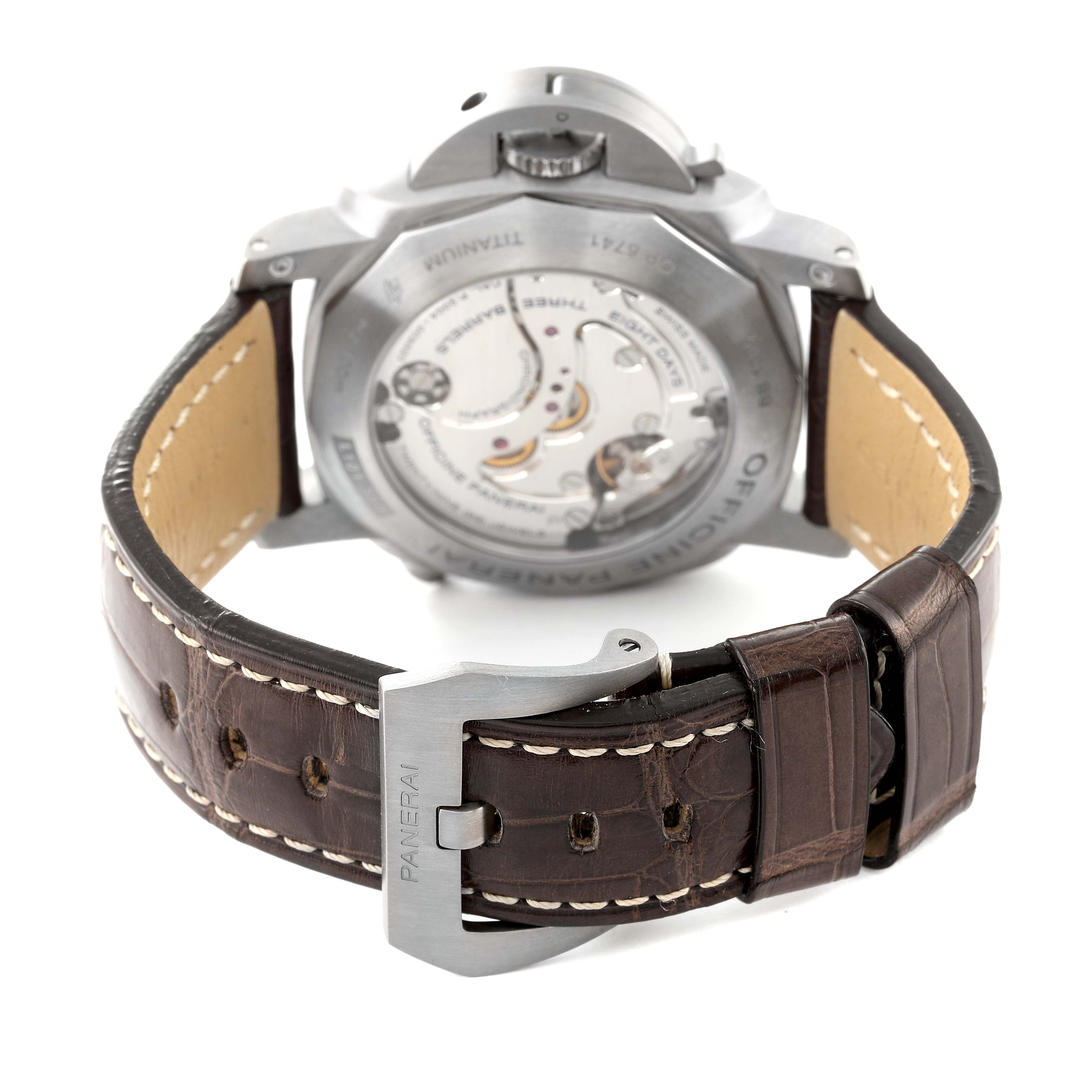 The image shows the back of a Panerai Luminor PAM00311 Men
s Titanium Brown Dial watch, featuring the movement and leather strap with a buckle.
