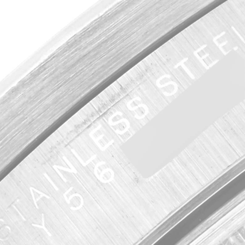 The image shows a close-up of the stainless steel casing of a Rolex Date 15210 Men's Stainless Steel Blue Dial 15210 Men's Stainless Steel Blue Dial model watch with partially visible engravings.