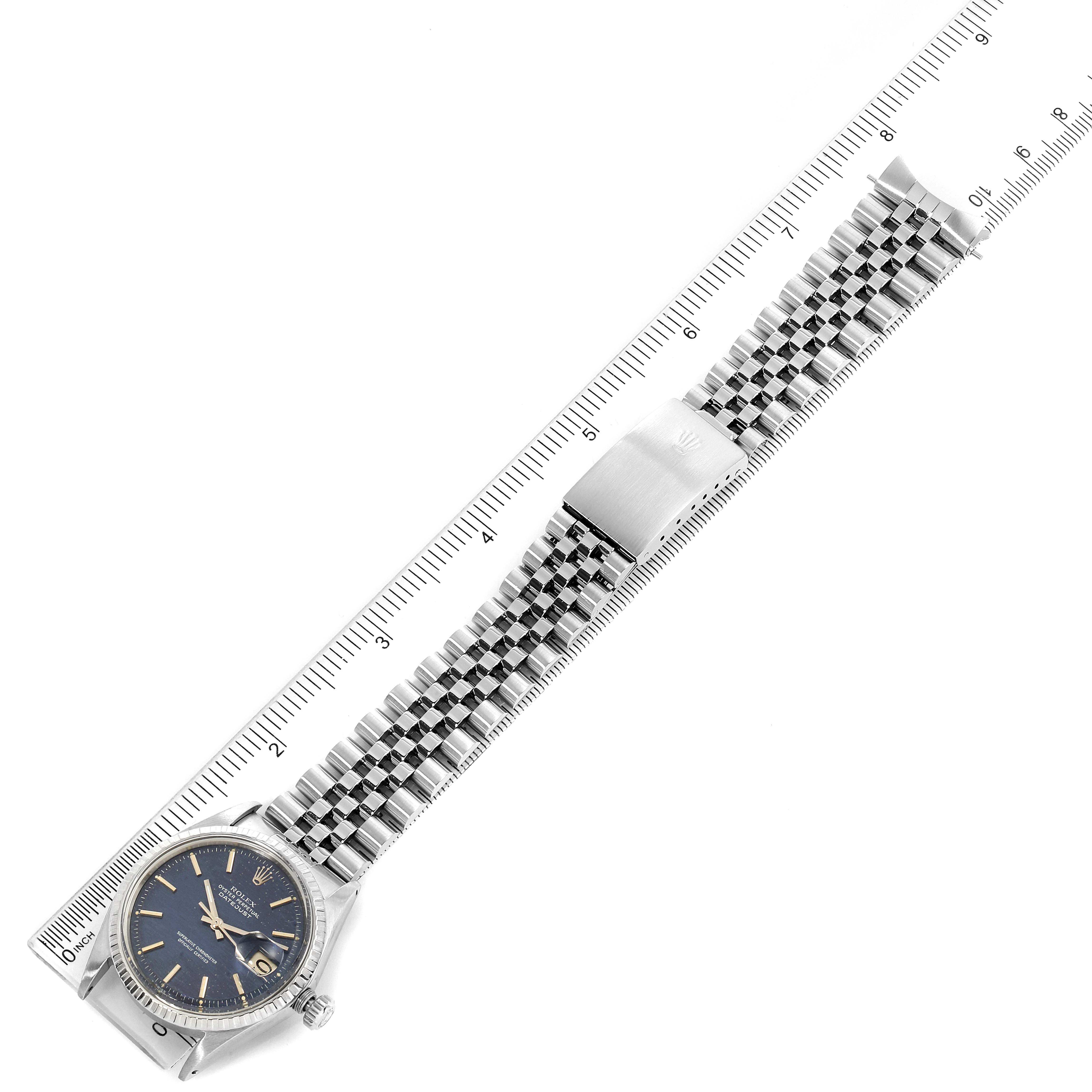 The image shows a Rolex Vintage Collection 1603 Men's Stainless Steel Blue Dial 1603 Men's Stainless Steel Blue Dial watch from an overhead angle, highlighting the face, stainless steel band, and clasp, with a ruler beside it.