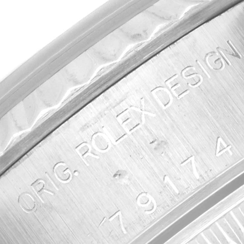 This is a close-up of the case side of a Rolex Datejust 79174 Women's Stainless Steel Blue Dial 79174 Women's Stainless Steel Blue Dial watch, showcasing engraved markings.
