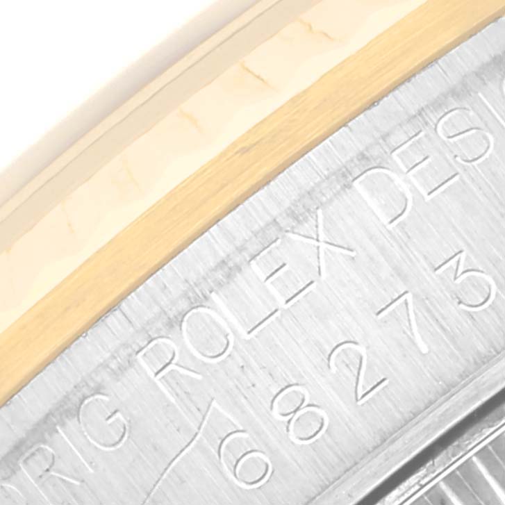 The image shows a close-up angle of the bezel and part of the engraved case of a Mid-Size Rolex watch.