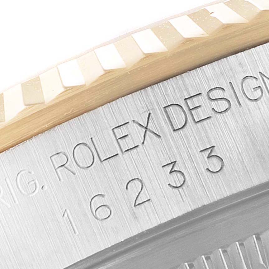This close-up image shows the side profile of a Rolex Datejust 16233 Men's Steel and Gold (two tone) Champagne Dial 16233 Men's Steel and Gold (two tone) Champagne Dial watch, focusing on its engraved model number and fluted bezel.