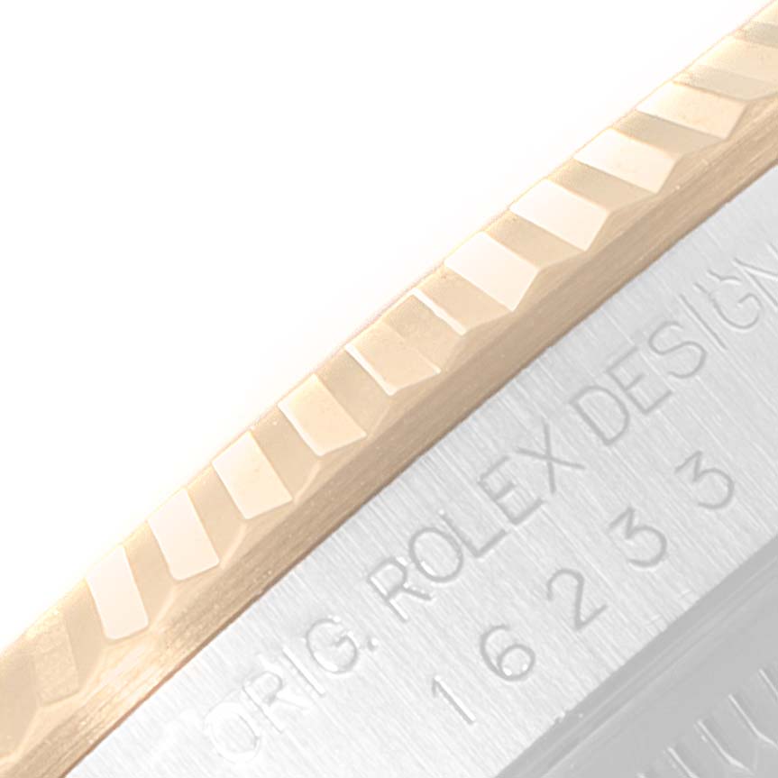 This image shows the edge of the bezel and part of the case with engraving on a Rolex Datejust 16233 Men's Steel and Gold (two tone) Black Dial 16233 Men's Steel and Gold (two tone) Black Dial watch.