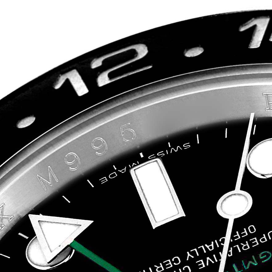 The image shows a close-up of the Rolex GMT-Master 116710 Men's Stainless Steel Black Dial 116710 Men's Stainless Steel Black Dial's bezel, dial, and hands at an oblique angle.