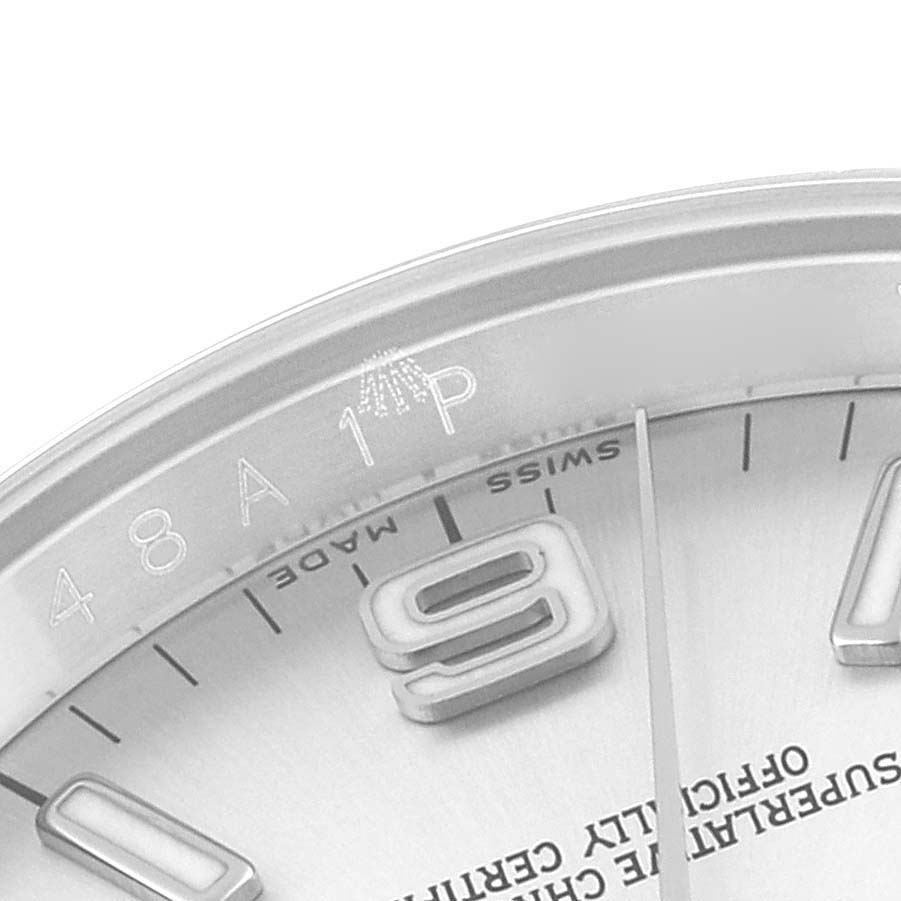 The image shows a close-up of the dial edge, bezel, and part of the 9 o
clock marker of a Rolex Oyster Perpetual 116000 Men
s Stainless Steel Silver Dial 116000 Men
s Stainless Steel Silver Dial watch.