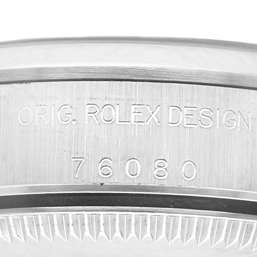 The image shows a close-up view of the side of a Rolex Oyster Perpetual 76080 Women's Stainless Steel Pink Dial 76080 Women's Stainless Steel Pink Dial watch, highlighting the engraved serial number.