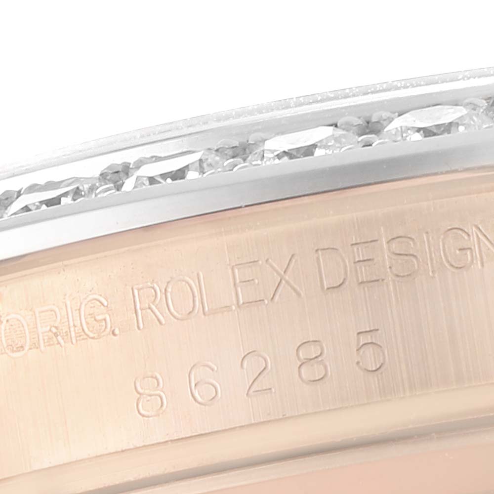This close-up image of the Rolex Pearlmaster 86285 Men's Rose Gold Blue Dial 86285 Men's Rose Gold Blue Dial watch shows part of the casing with engraved text and a portion of the diamond-encrusted bezel.
