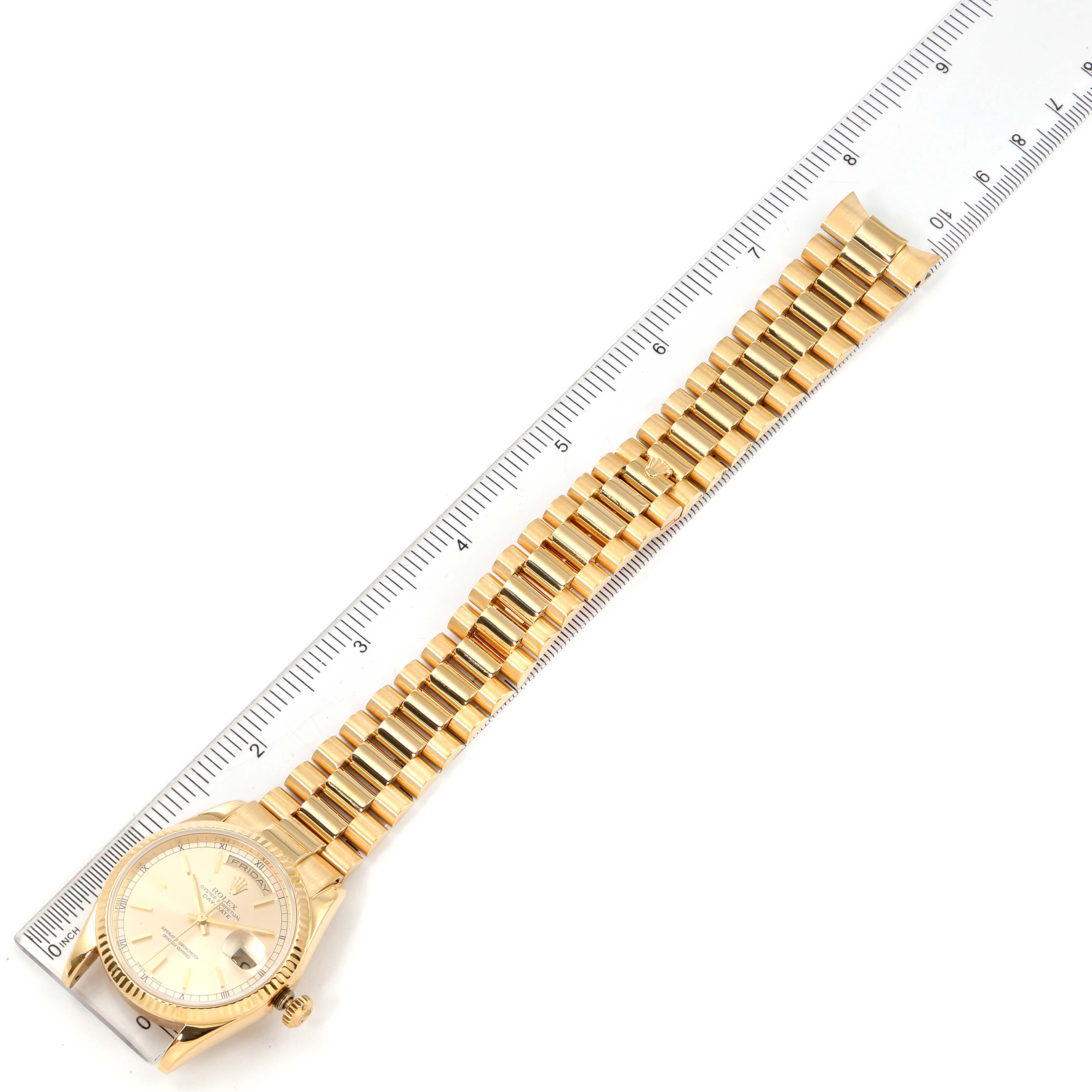 The image shows an overhead view of a Rolex President 118238 Men's Yellow Gold Champagne Dial 118238 Men's Yellow Gold Champagne Dial watch with its face and bracelet laid next to a ruler for scale.