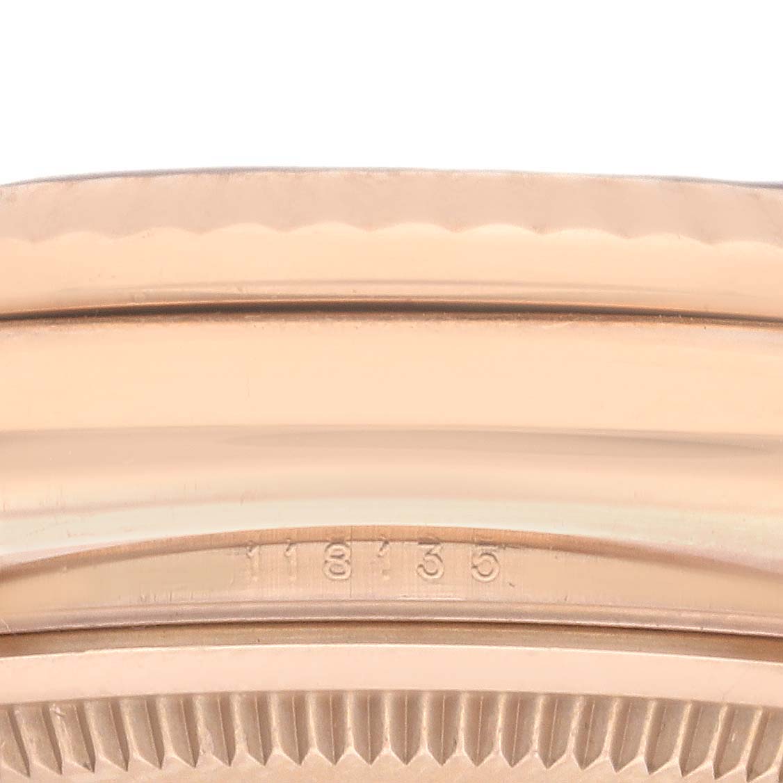 The image shows a close-up of the fluted bezel and edge of a Rolex President 118135 Men
s Rose Gold Brown Dial 118135 Men
s Rose Gold Brown Dial watch, highlighting its detail and model number.