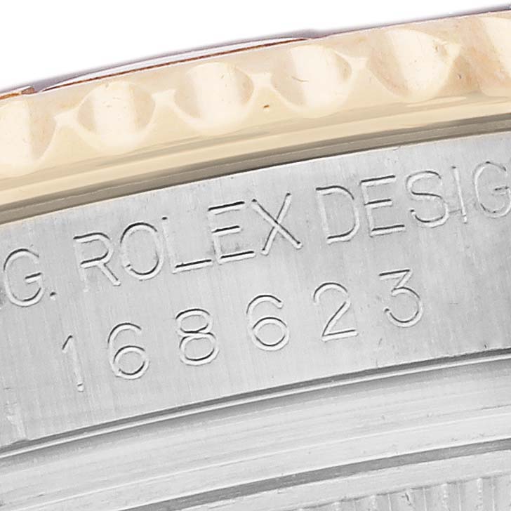 The image shows a close-up of the side of a Rolex Yacht-Master 168623 Men's Steel and Gold (two tone) Mother of Pearl Dial 168623 Men's Steel and Gold (two tone) Mother of Pearl Dial watch, focusing on the engraved model number and bezel edge.