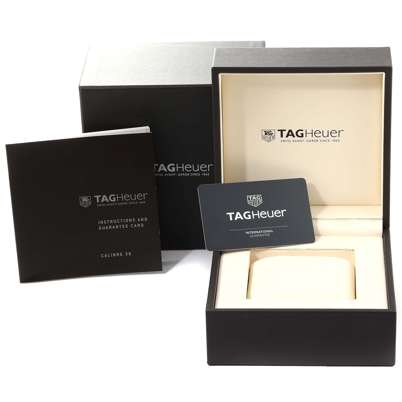 The image shows the packaging and accessories for the Tag Heuer Carrera CAR2B11.BA0799 Men's Stainless Steel Grey Dial CAR2B11.BA0799 Men's Stainless Steel Grey Dial watch, including the box, manual, and guarantee card.