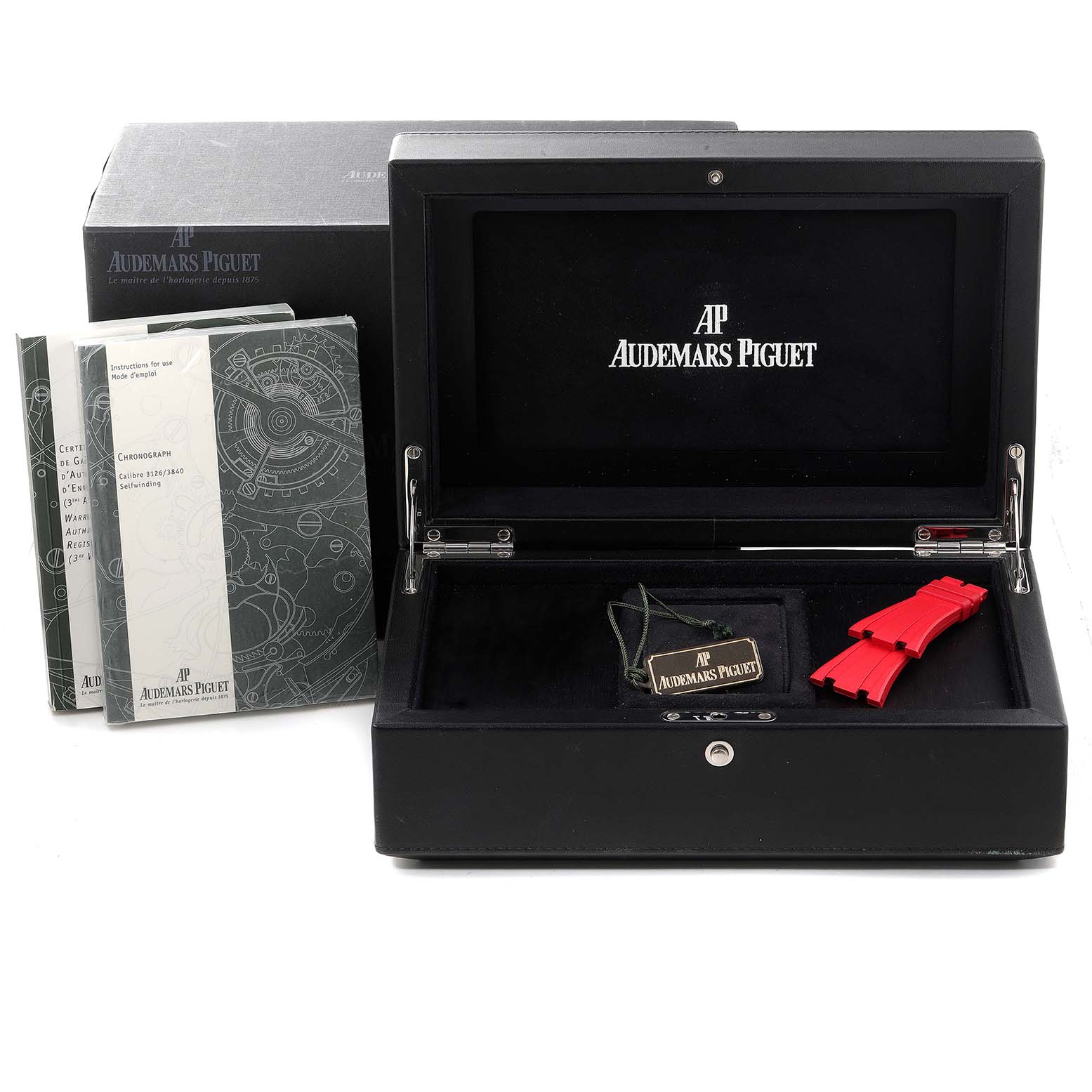The image features an open Audemars Piguet watch box for the Royal Oak Offshore model, along with booklets and a red strap.