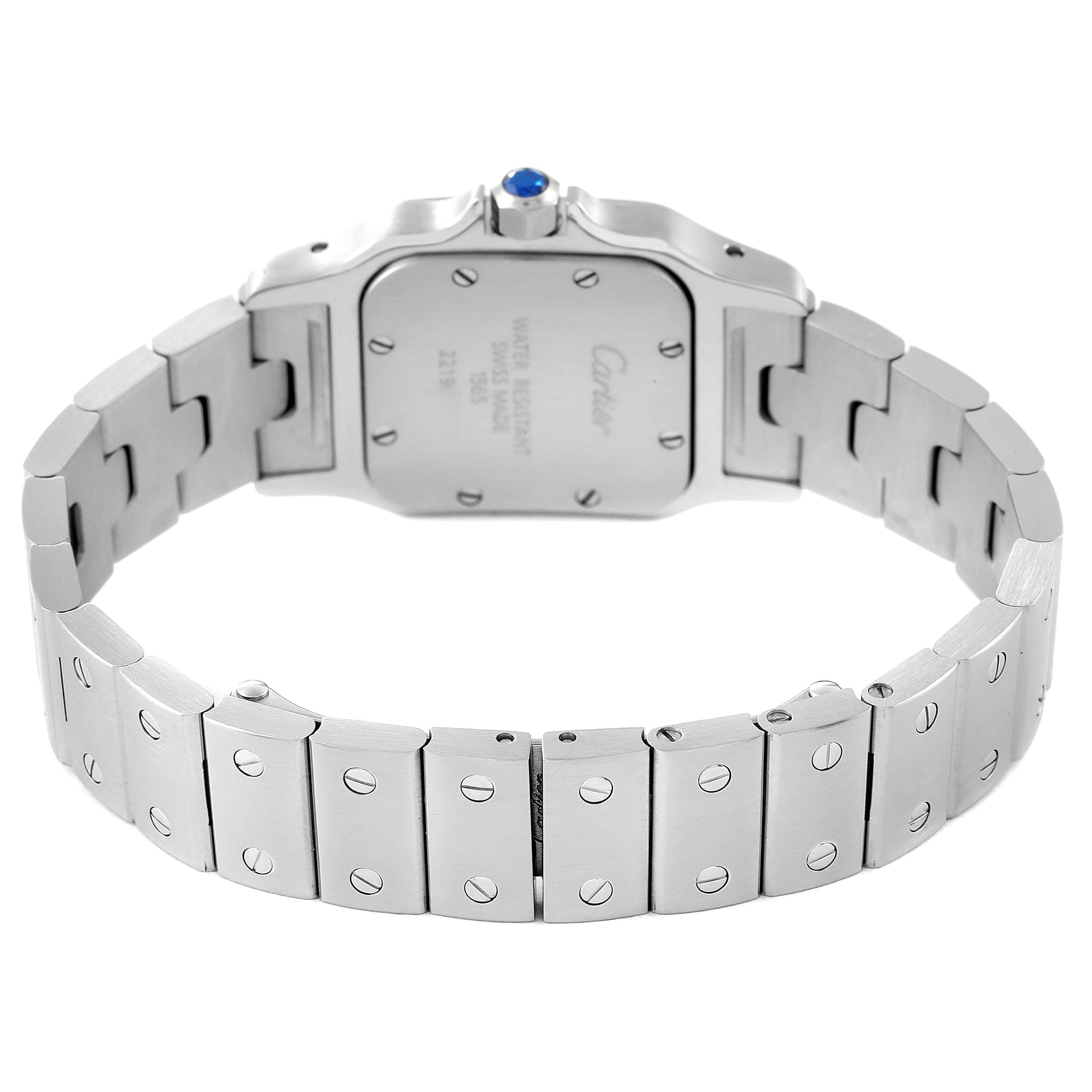 The image shows the back of a Santos model by Cartier, highlighting the caseback and metal bracelet.