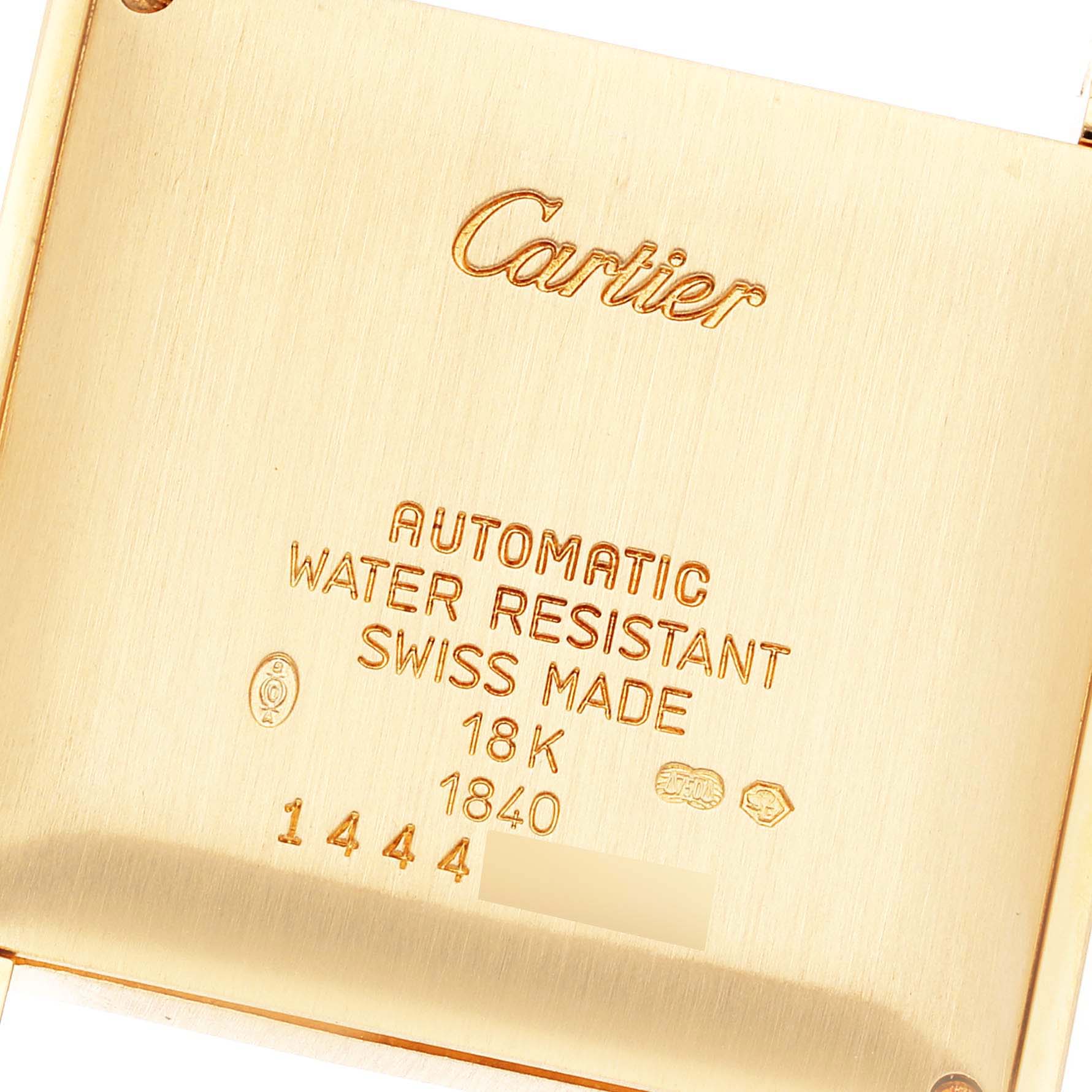 The image shows the back case of a Cartier Tank Française watch, displaying engravings with specifications and branding.