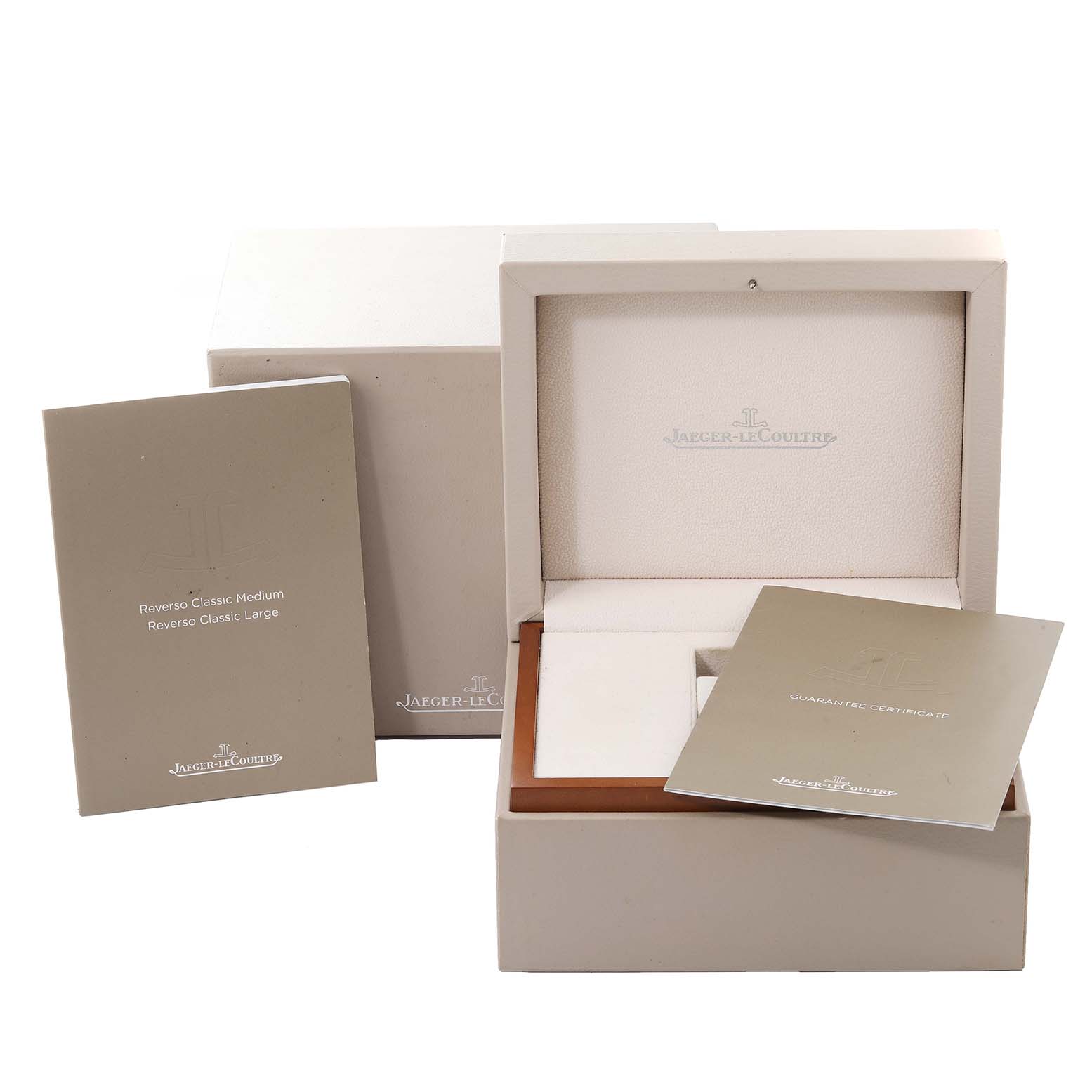 The image shows the packaging and accessories, including manuals and certificates, for a Jaeger-LeCoultre Reverso watch.