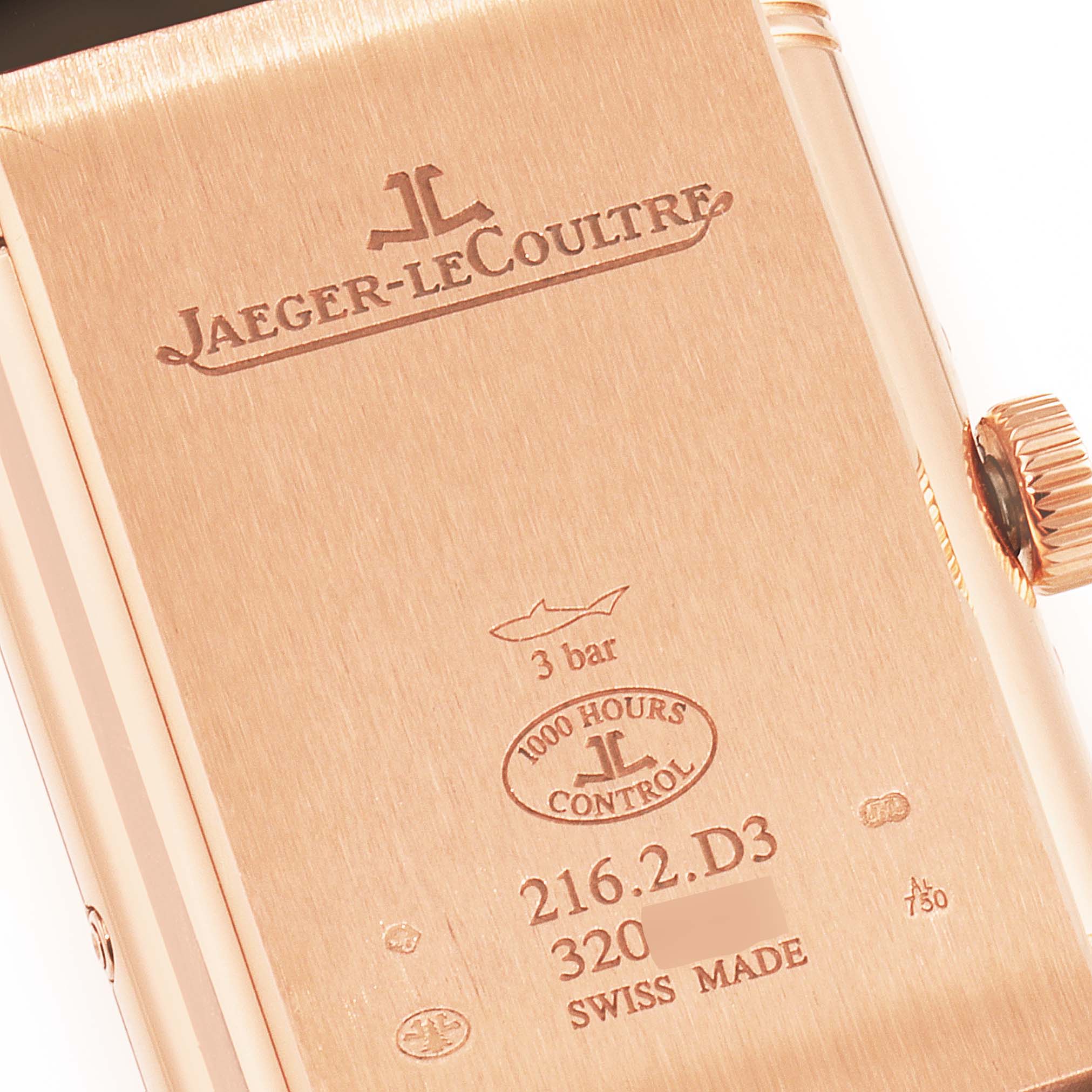 The image shows the engraved case back and crown of the Jaeger-LeCoultre Reverso watch.