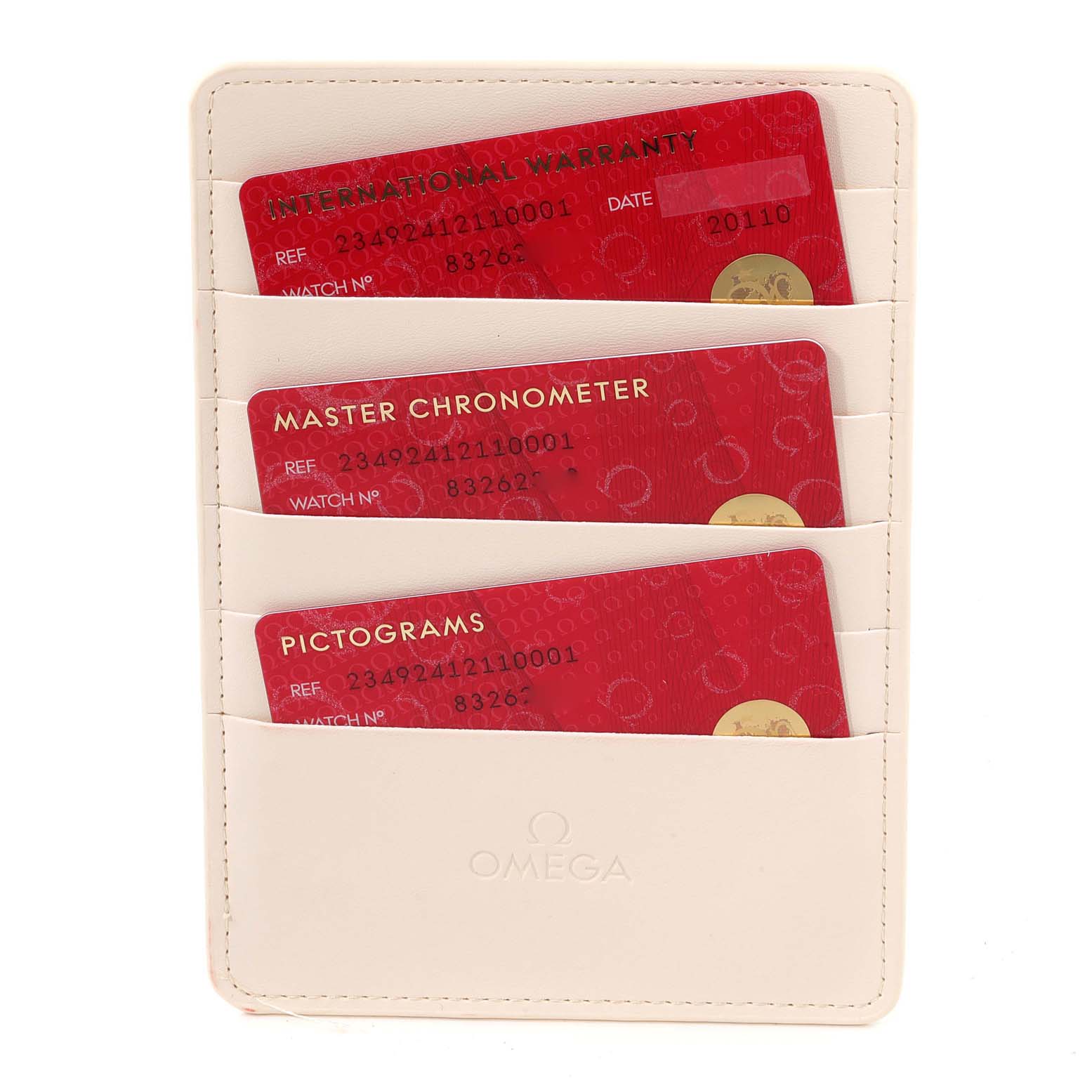 The image shows three red cards labeled "International Warranty," "Master Chronometer," and "Pictograms" in an Omega cardholder.