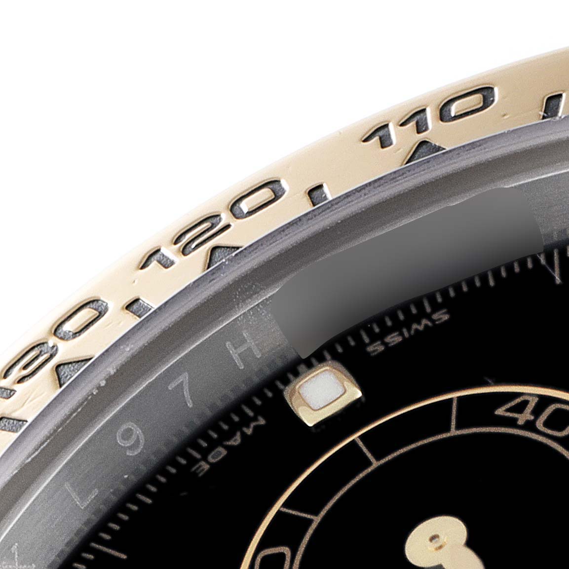 This image shows a close-up of the Rolex Daytona 116503 Men's Steel and Gold (two tone) Black Dial 116503 Men's Steel and Gold (two tone) Black Dial watch bezel and partial dial.