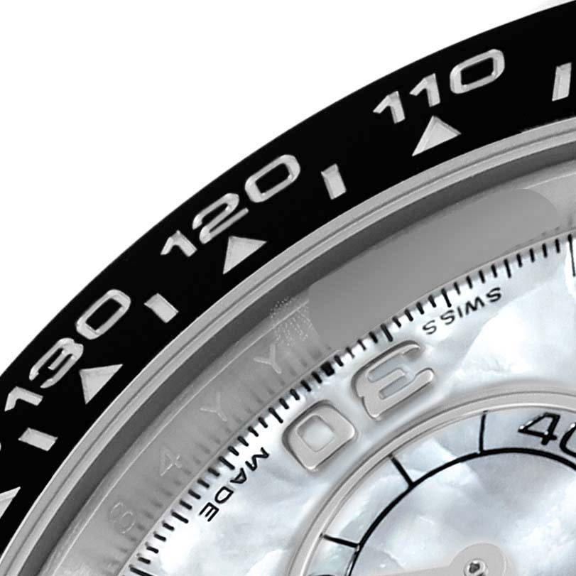 This close-up image of the Rolex Daytona 116519LN Men's White Gold Mother of Pearl Dial 116519LN Men's White Gold Mother of Pearl Dial watch shows the bezel with engraved numerals and a part of the dial indicating "SWISS MADE."