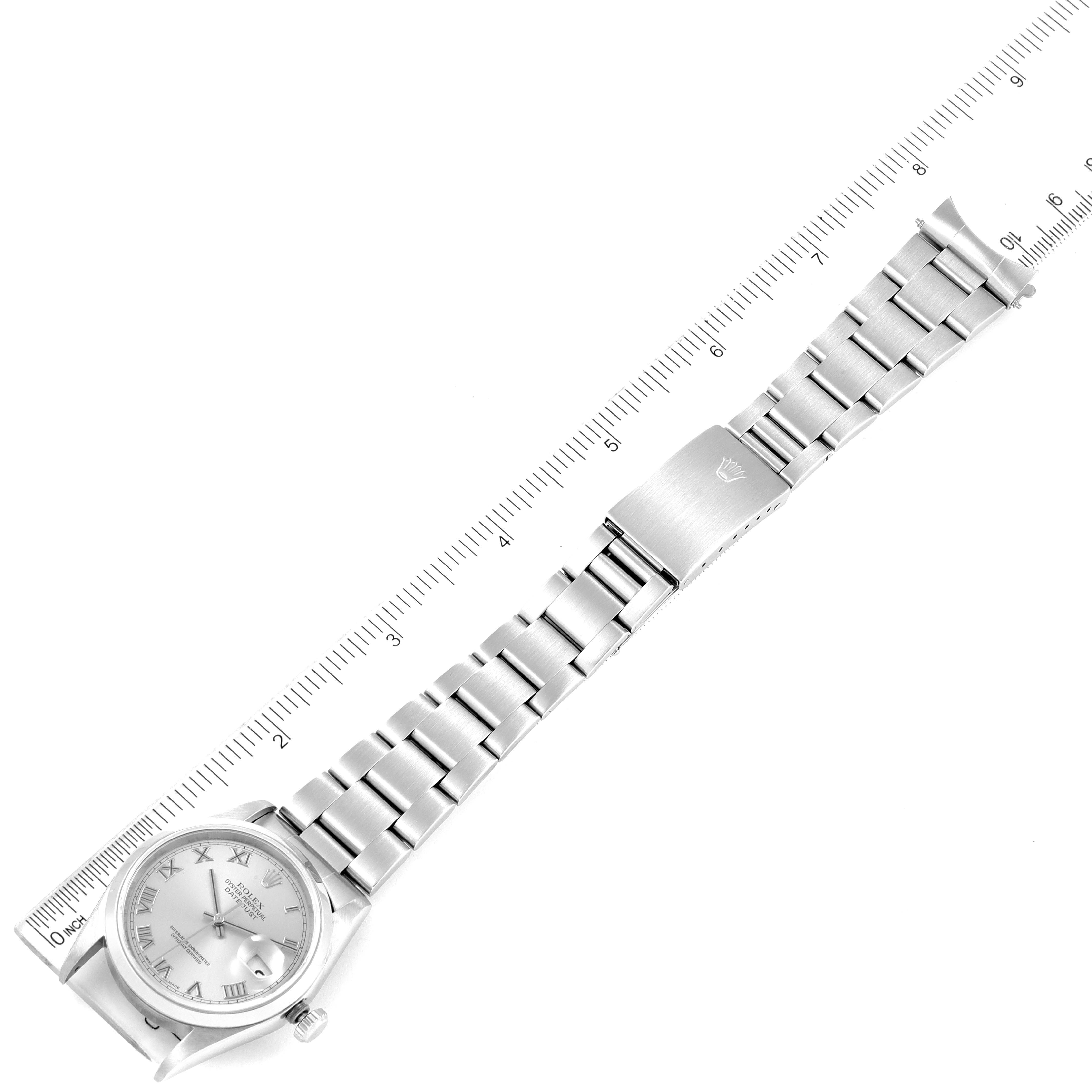 This is a top view of a Rolex Datejust 16200 Men
s Stainless Steel Grey Dial 16200 Men
s Stainless Steel Grey Dial watch showing its face, metal bracelet, and clasp, along with a ruler for size reference.