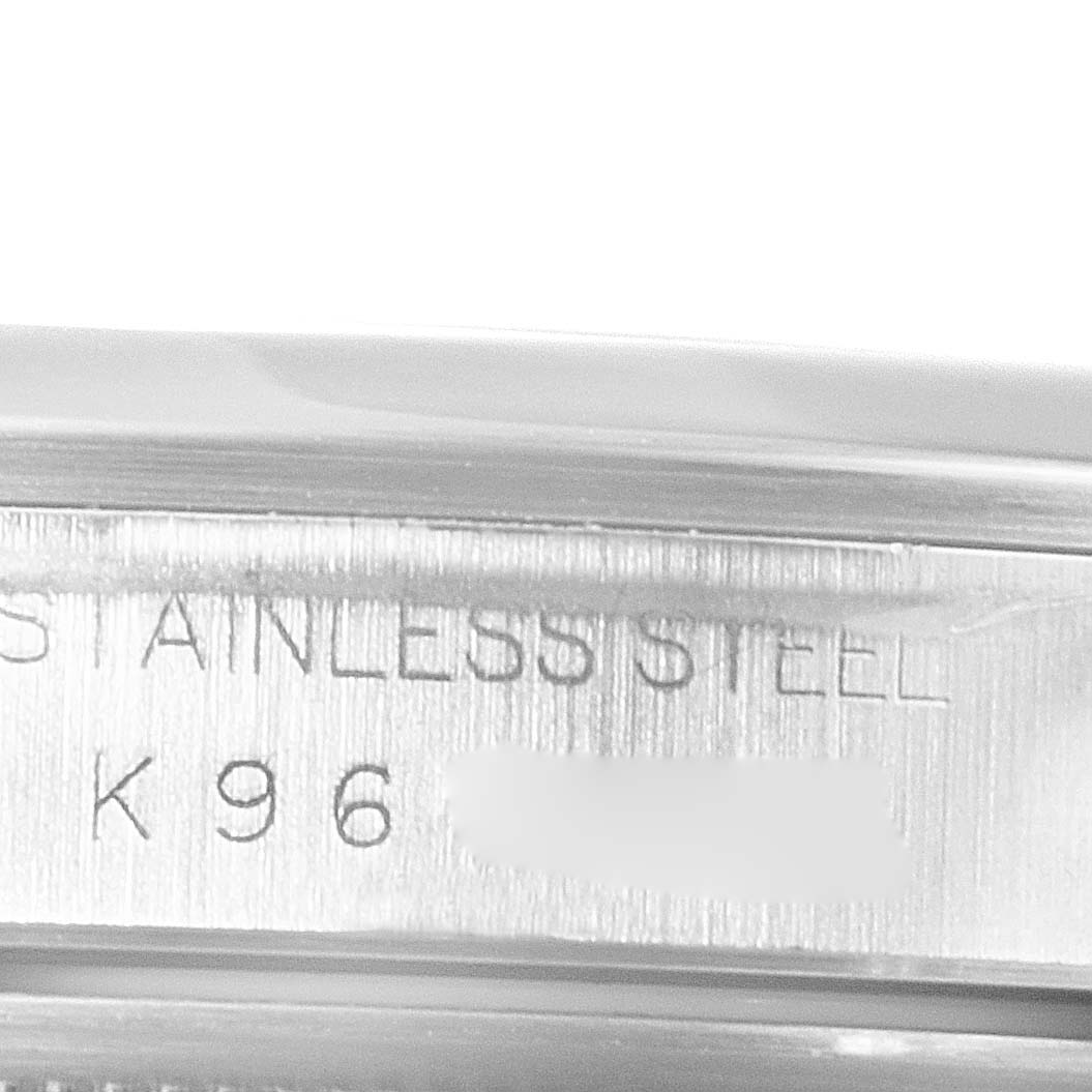 The image shows a close-up shot of the inner side of the case of a Datejust model by Rolex, revealing "STAINLESS STEEL" engraving.