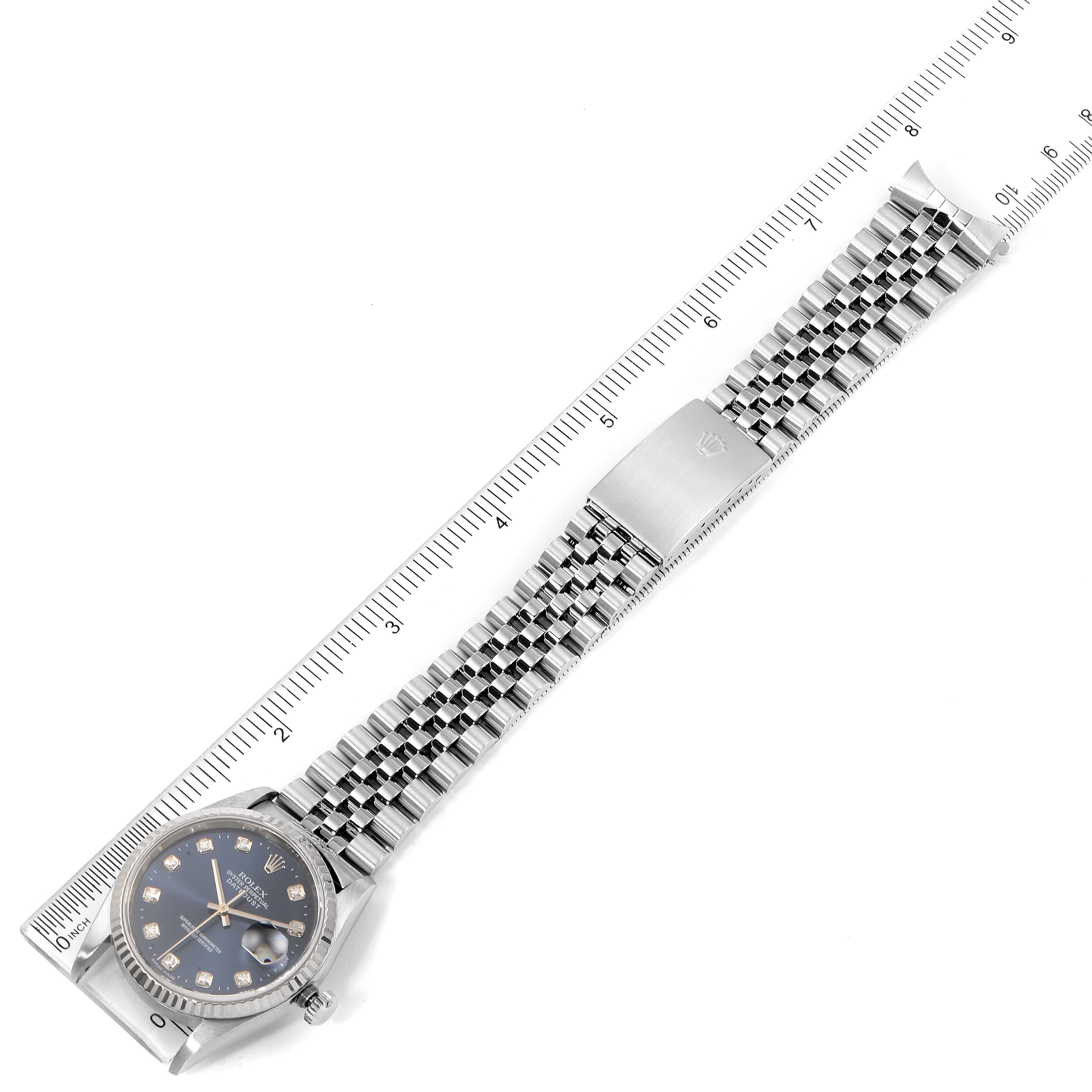 The image shows a Rolex Datejust 16234 Men
s Stainless Steel Blue Dial 16234 Men
s Stainless Steel Blue Dial watch laid flat with a ruler for scale, displaying the face and entire bracelet.
