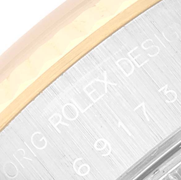 The image shows a close-up of the side case of a Rolex Datejust 69173 Women's Steel and Gold (two tone) Blue Dial 69173 Women's Steel and Gold (two tone) Blue Dial, featuring part of the branding and design engraving.