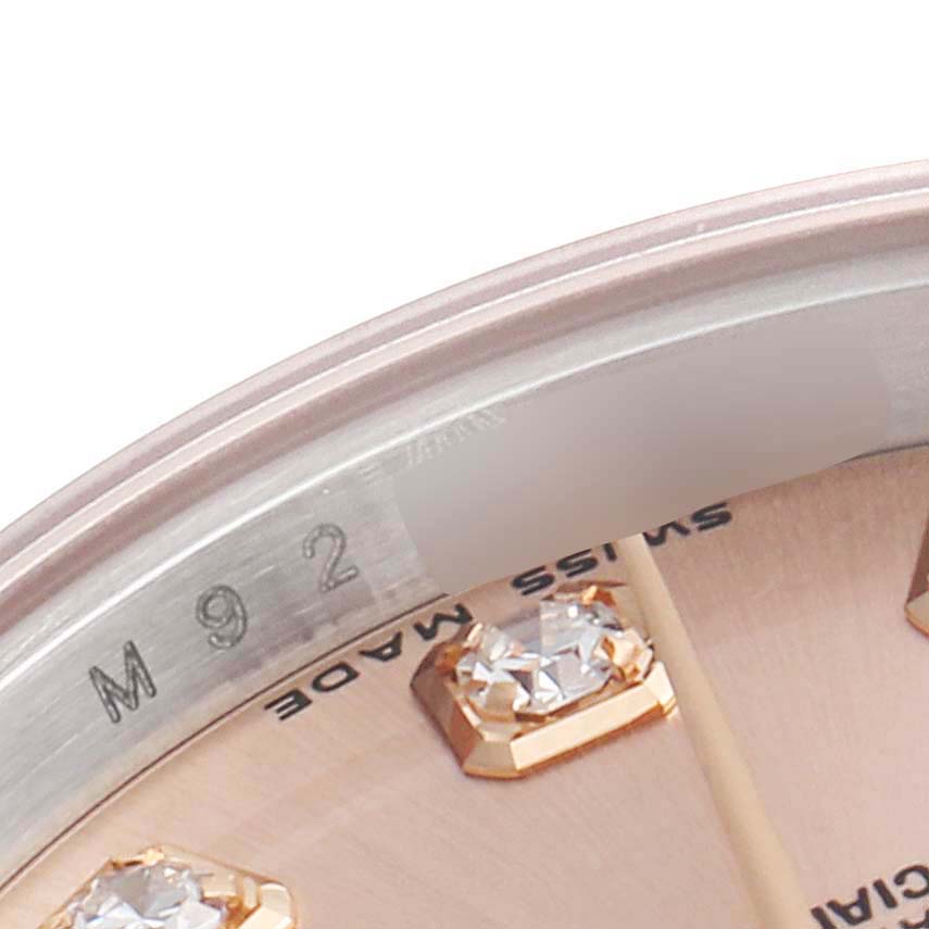 This close-up zooms in on the dial and diamond markers of the Rolex Datejust 179171 Women's Rose Gold Pink Dial 179171 Women's Rose Gold Pink Dial model, showing part of the bezel with engravings.