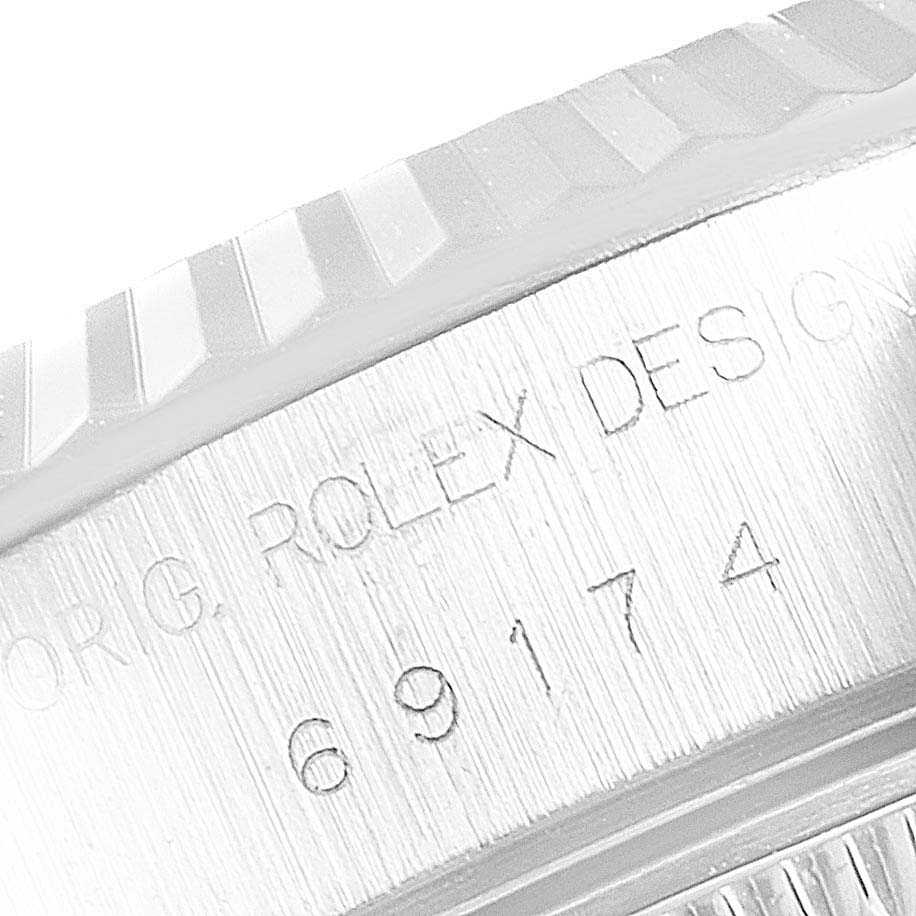 This close-up photo of the Rolex Datejust 69174 Women's Stainless Steel Pink Dial 69174 Women's Stainless Steel Pink Dial shows the engraved model number on the watch case edge and a portion of the fluted bezel.