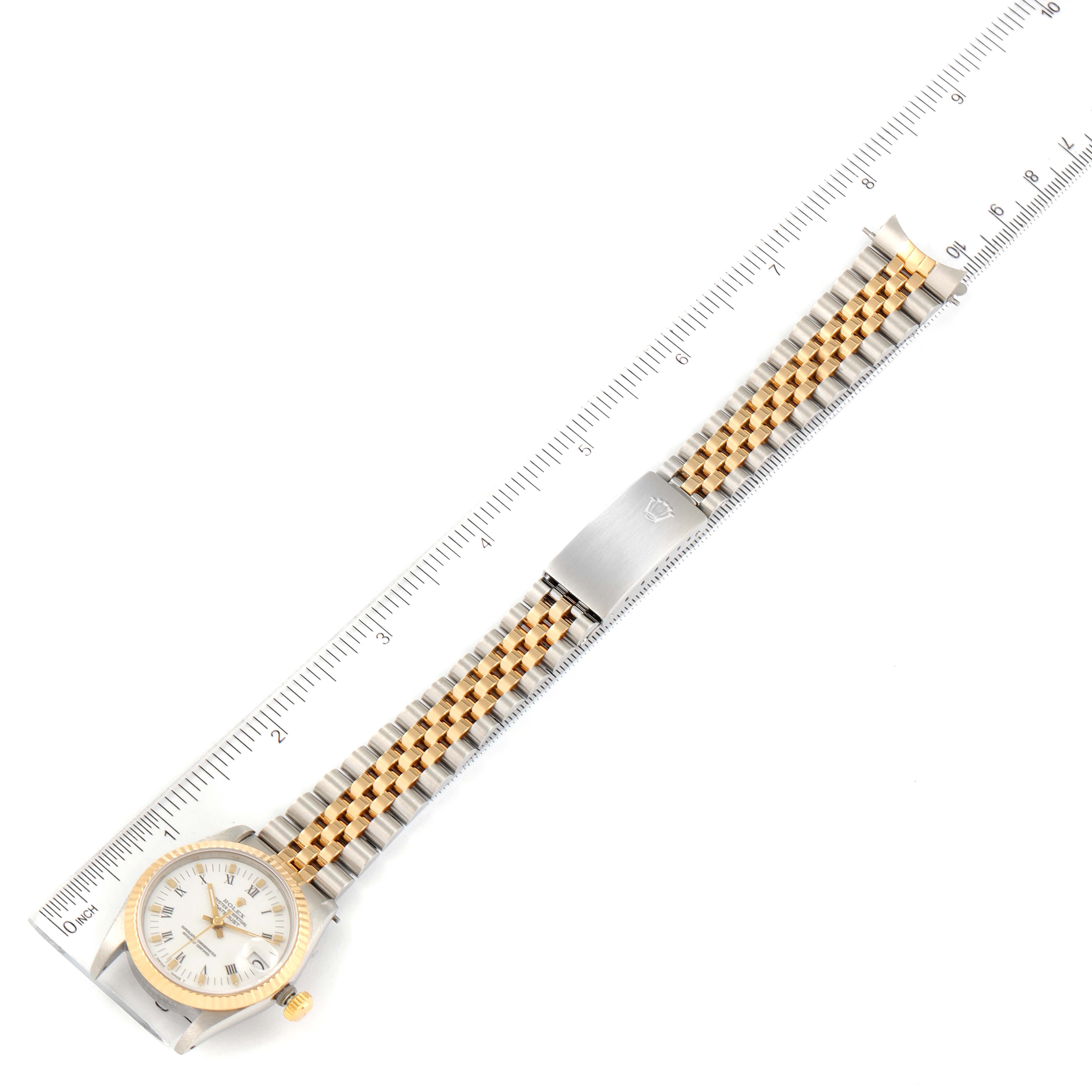 The image shows a bird
s-eye view of a Rolex Mid-Size 68273 Women
s Steel and Gold (two tone) White Dial 68273 Women
s Steel and Gold (two tone) White Dial model watch, including the full dial, bracelet, and clasp, against a ruler for size reference.