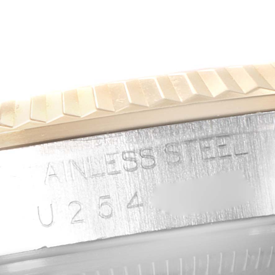 The image shows a close-up of the side engraving and the fluted bezel of a Rolex Datejust 16233 Men's Steel and Gold (two tone) White Dial 16233 Men's Steel and Gold (two tone) White Dial.