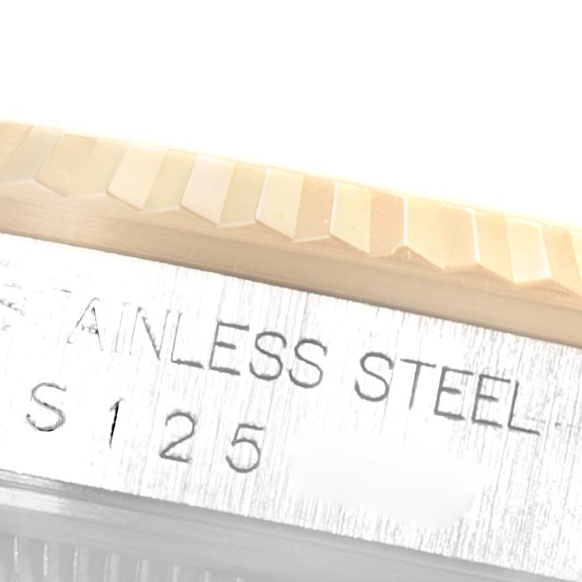 This close-up image of the Rolex Datejust 16233 Men's Steel and Gold (two tone) White Dial 16233 Men's Steel and Gold (two tone) White Dial watch shows the fluted bezel and part of the engraved stainless steel case.