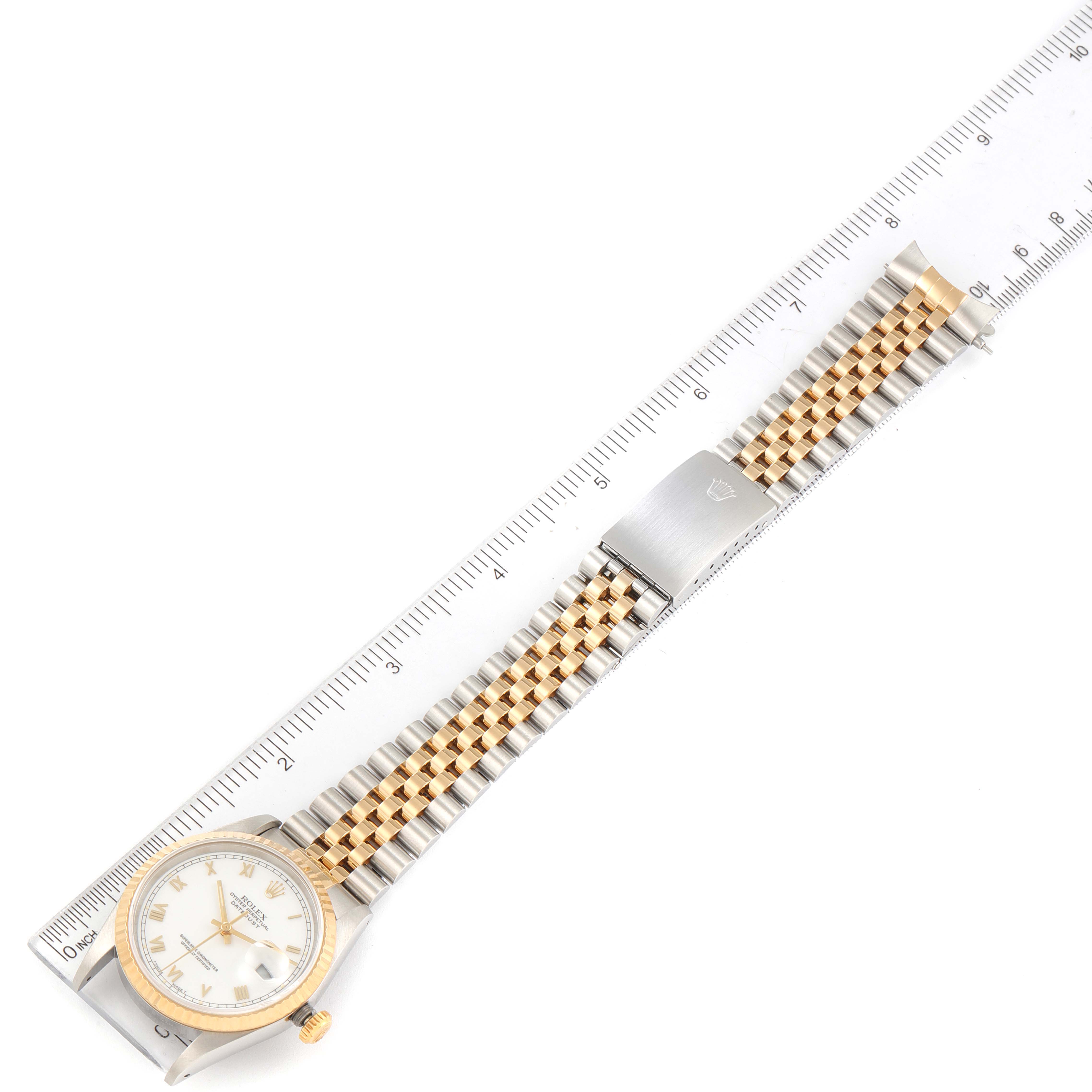 The image shows a Rolex Datejust 16233 Men's Steel and Gold (two tone) White Dial 16233 Men's Steel and Gold (two tone) White Dial watch laid flat with its full bracelet and clasp, alongside a ruler for size reference.