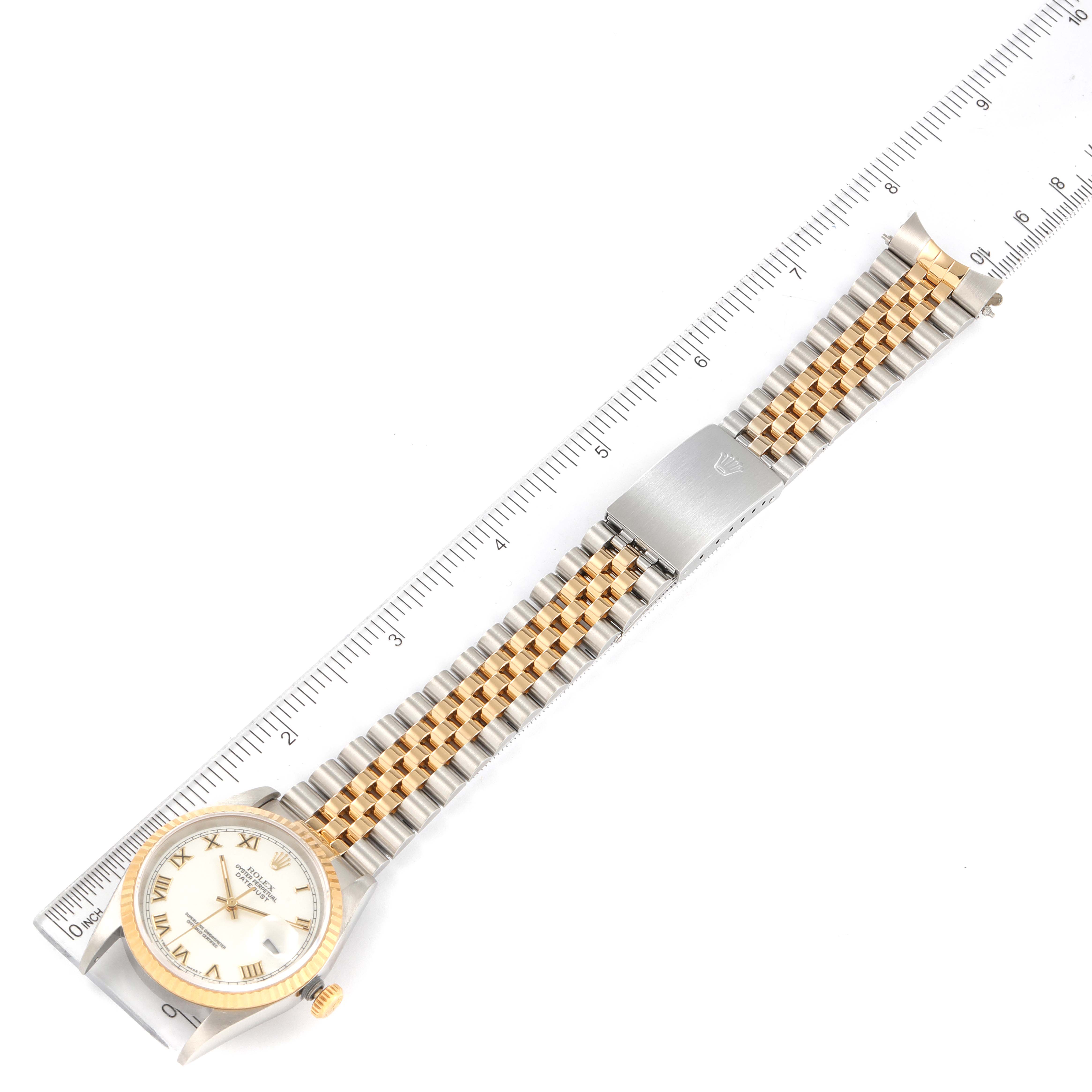 The Rolex Datejust 16233 Men's Steel and Gold (two tone) White Dial 16233 Men's Steel and Gold (two tone) White Dial watch is shown from a top-down angle, alongside a ruler, displaying the face, bezel, and full bracelet.