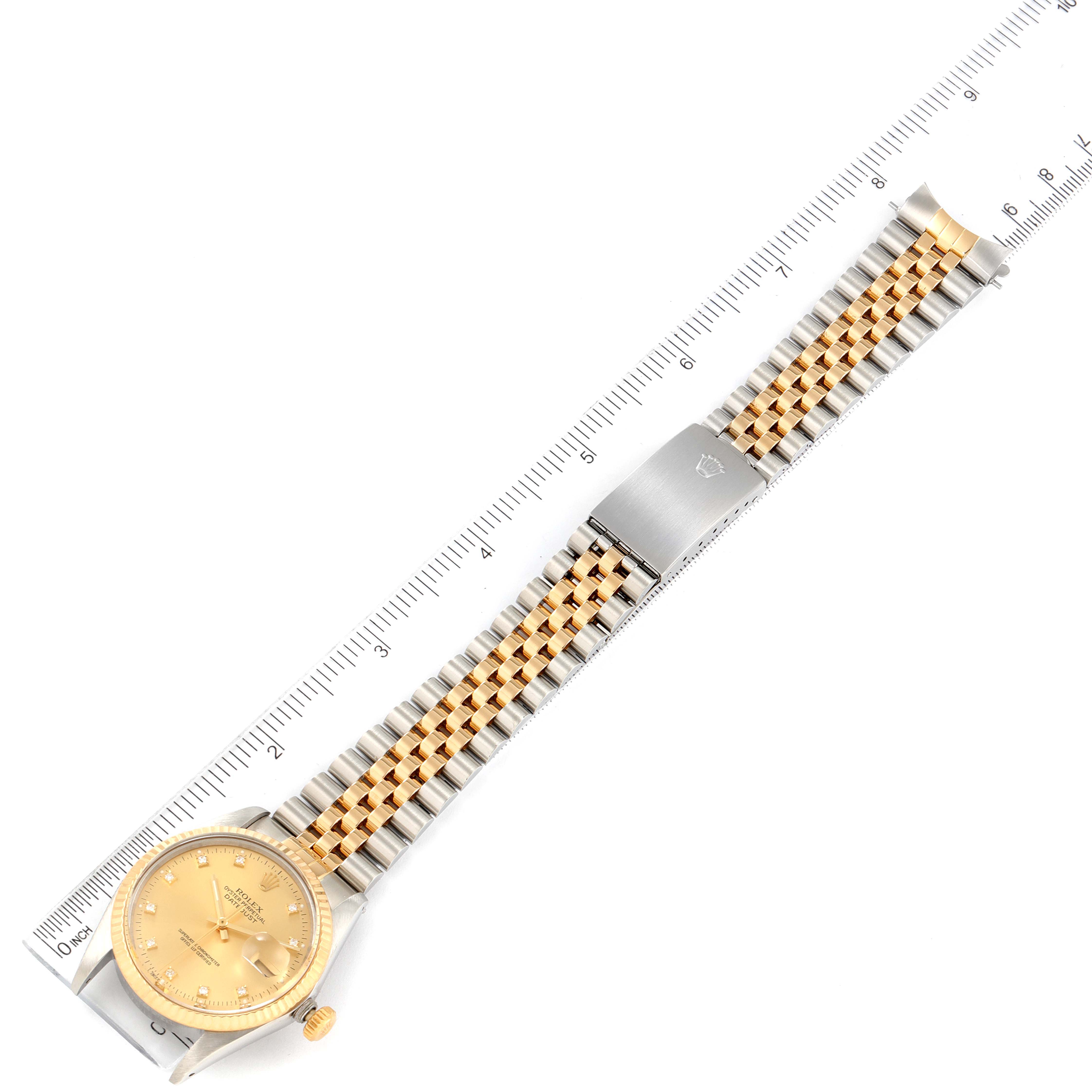 The image shows a Rolex Datejust 16013 Men
s Steel and Gold (two tone) Champagne Dial 16013 Men
s Steel and Gold (two tone) Champagne Dial watch laid flat with a ruler beside it; highlighting its face, bracelet, and clasp.