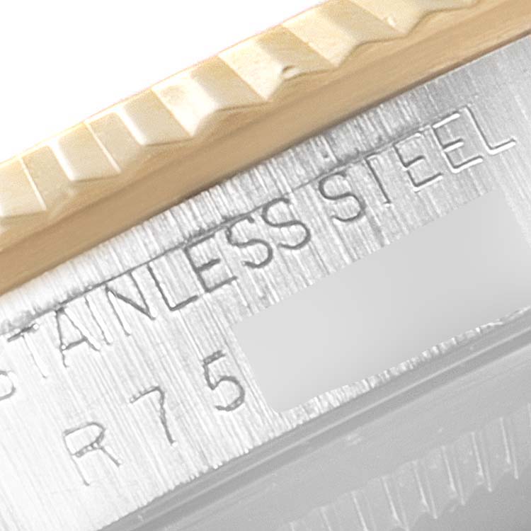 This is a close-up of a Rolex Datejust 16233 Men's Steel and Gold (two tone) Blue Dial 16233 Men's Steel and Gold (two tone) Blue Dial watch, showing part of the fluted bezel and the "STAINLESS STEEL" engraving.