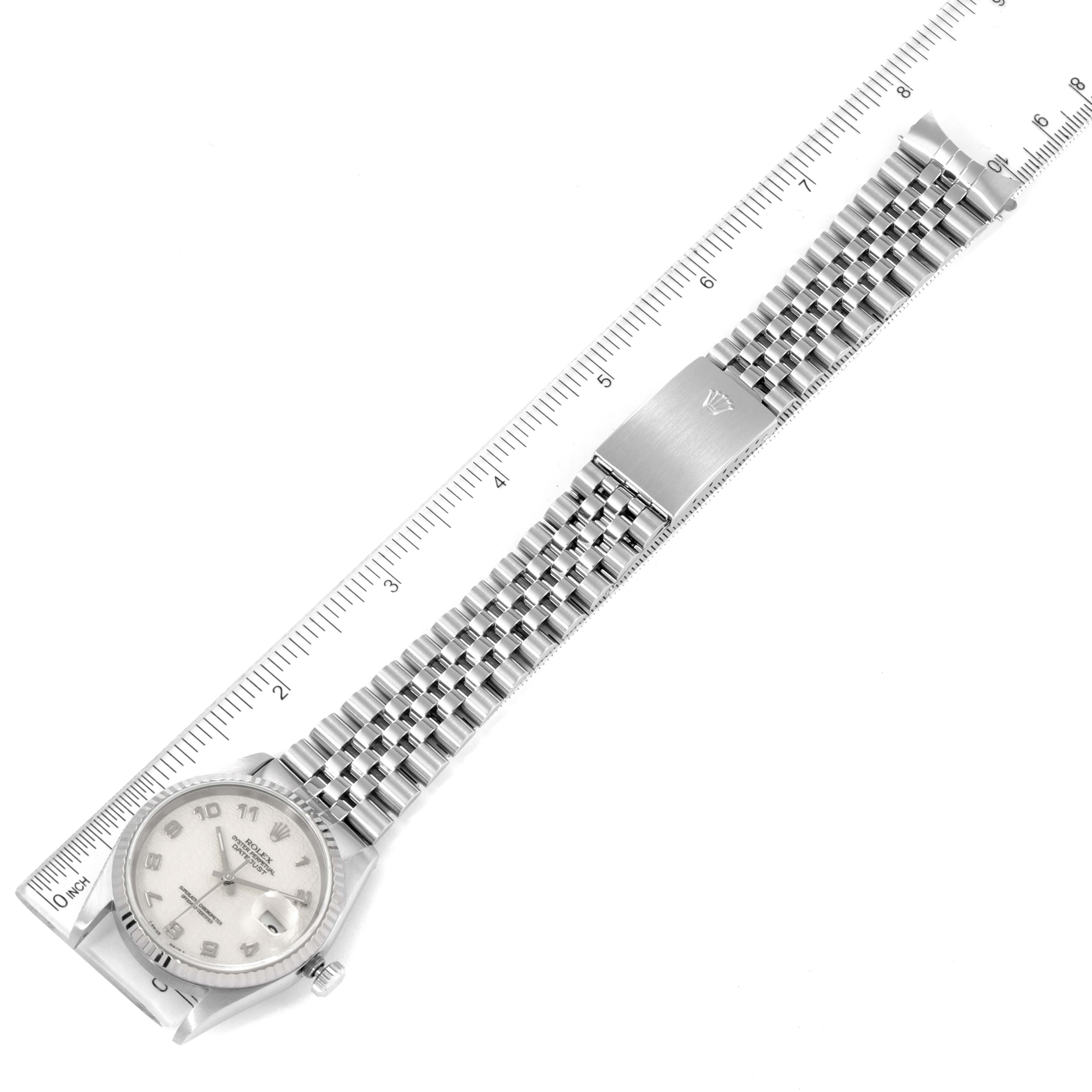 This Rolex Datejust 16234 Men's Stainless Steel Silver Dial 16234 Men's Stainless Steel Silver Dial watch is shown diagonally with a clear view of its stainless steel bracelet and clasp, alongside a ruler for scale.