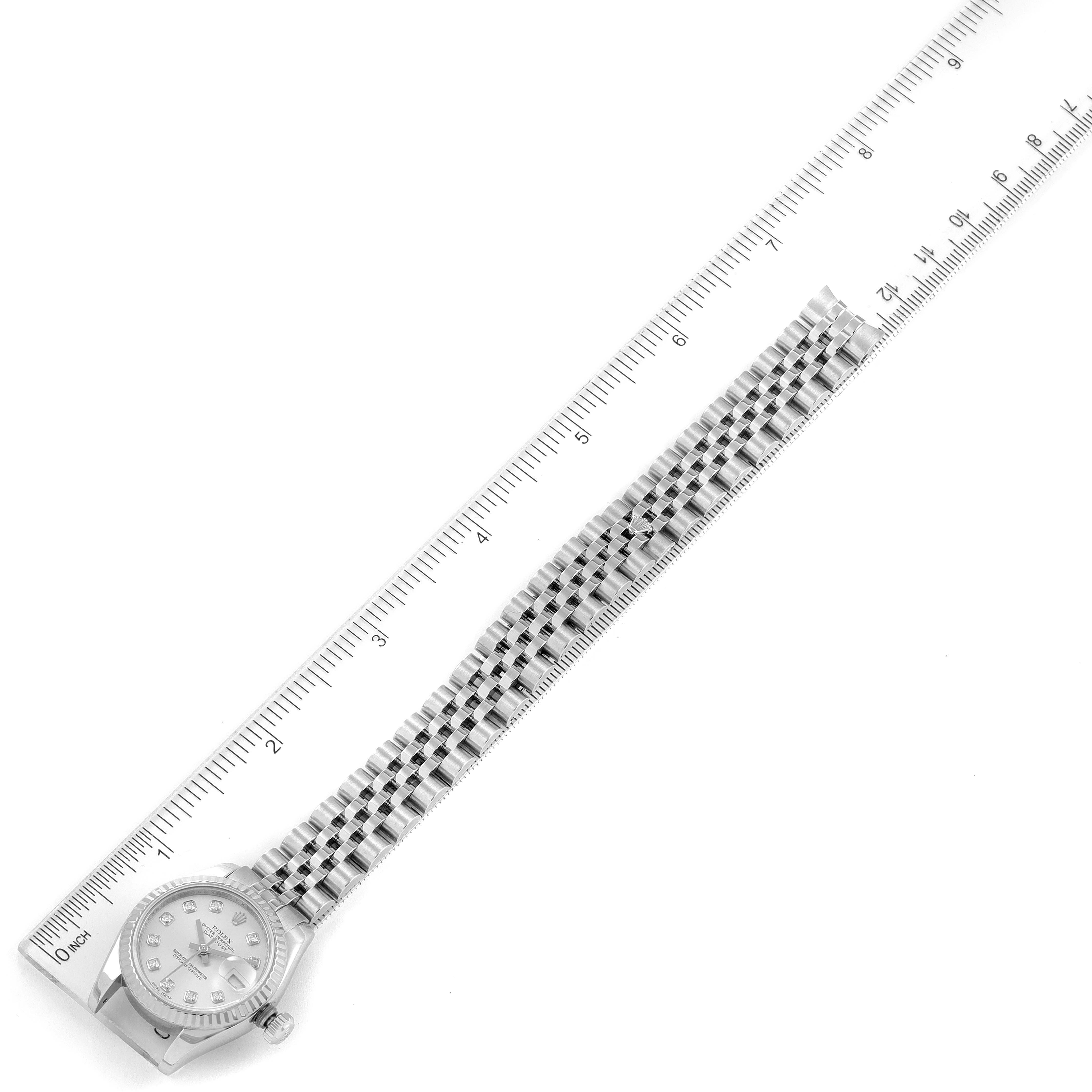 The Rolex Datejust 179174 Women
s Stainless Steel Silver Dial 179174 Women
s Stainless Steel Silver Dial watch is shown from a top-down angle next to a ruler, highlighting its face and full bracelet length.