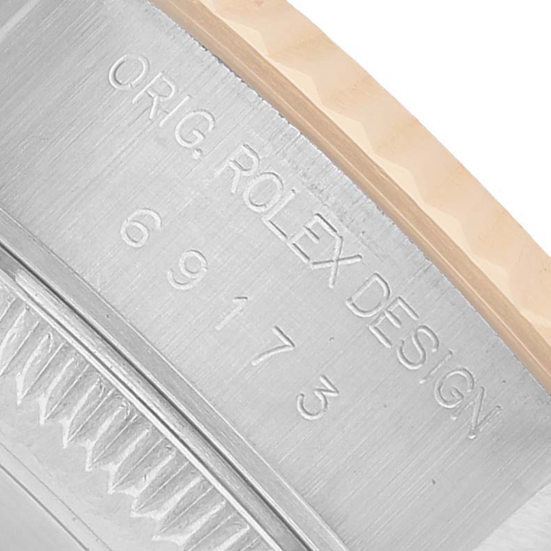 The image shows the case side of a Rolex Datejust 69173 Women's Steel and Gold (two tone) Black Dial watch with engravings of model information.