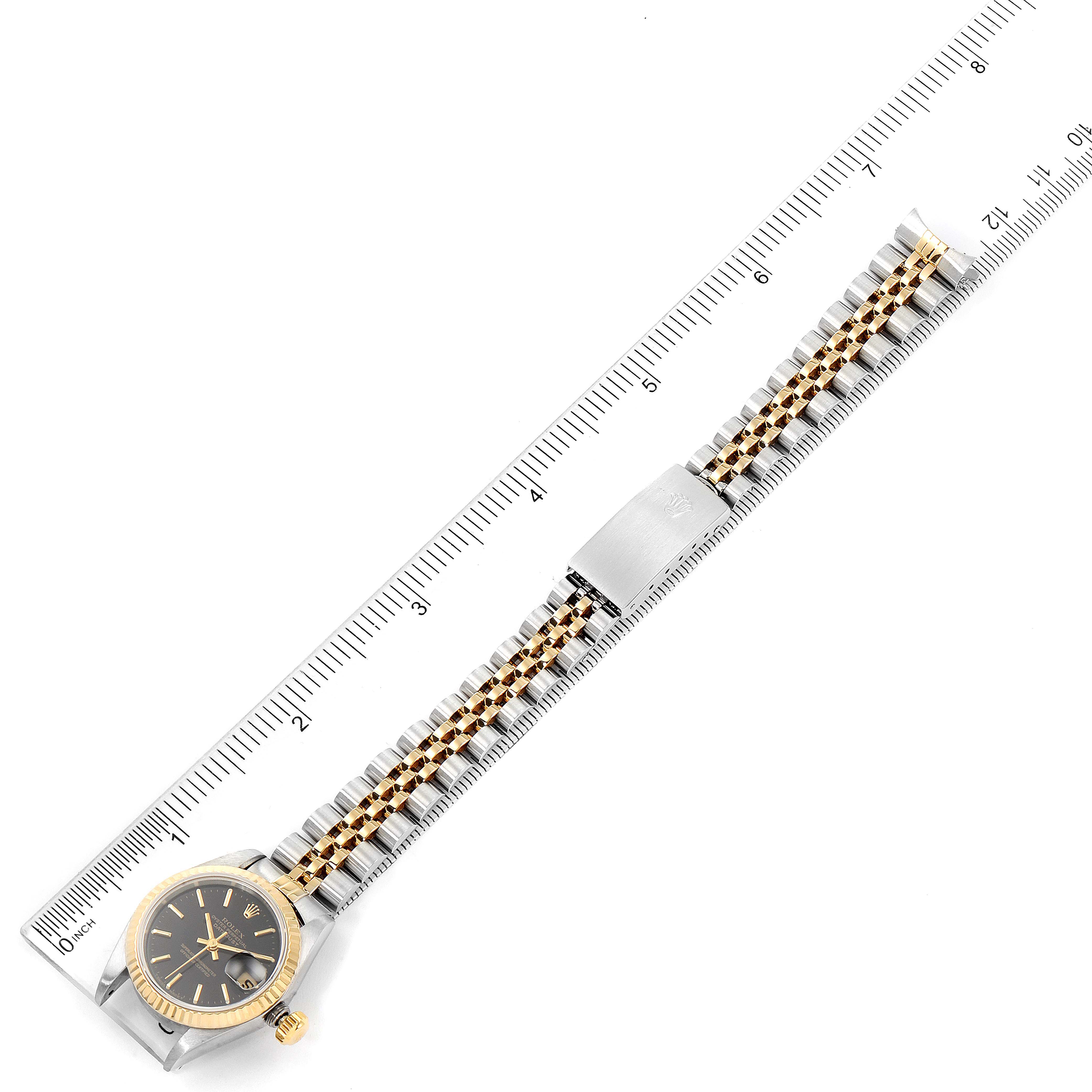 The image shows a full, flat view of the Rolex Datejust 69173 Women's Steel and Gold (two tone) Black Dial 69173 Women's Steel and Gold (two tone) Black Dial watch, including the dial, bezel, and bracelet, alongside a measurement ruler.
