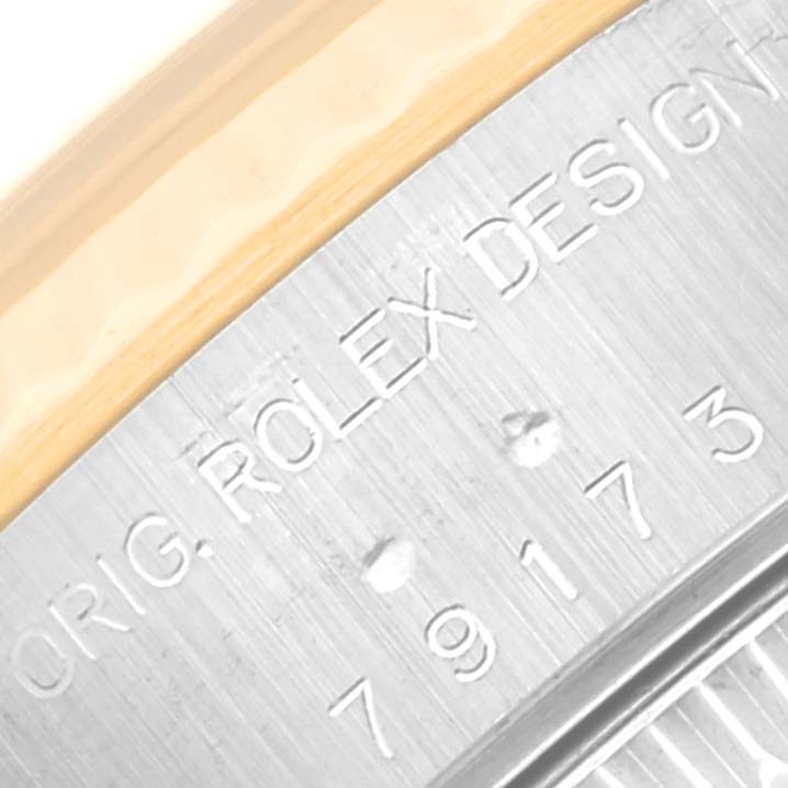 Close-up of the side of a Rolex Datejust 79173G Women's Steel and Gold (two tone) Champagne Dial 79173G Women's Steel and Gold (two tone) Champagne Dial, showing the Rolex engraving and part of the bezel.