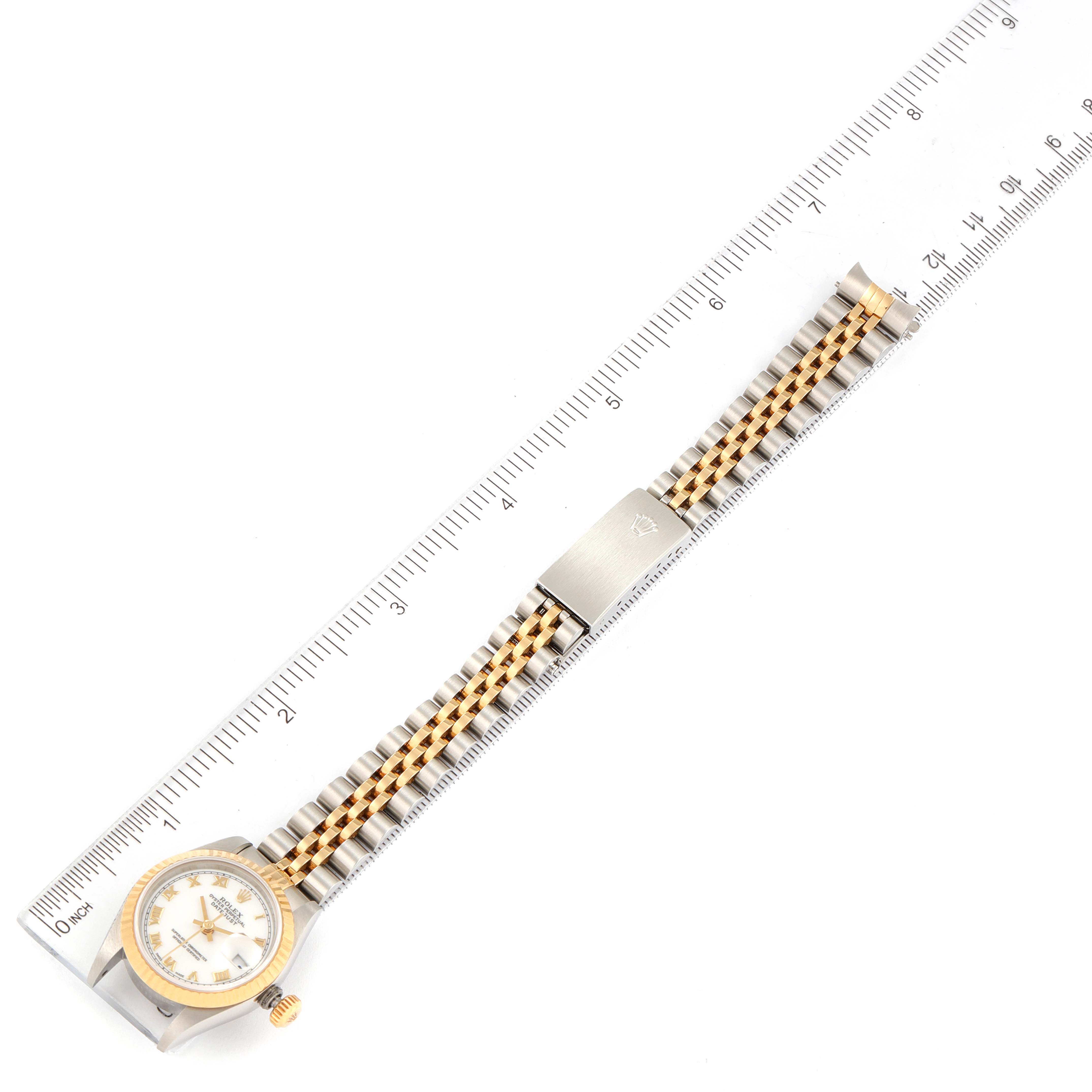 The image shows a top-down view of a Rolex Datejust 69173 Women
s Stainless Steel White Dial 69173 Women
s Stainless Steel White Dial watch with its entire face and strap extended alongside a ruler.