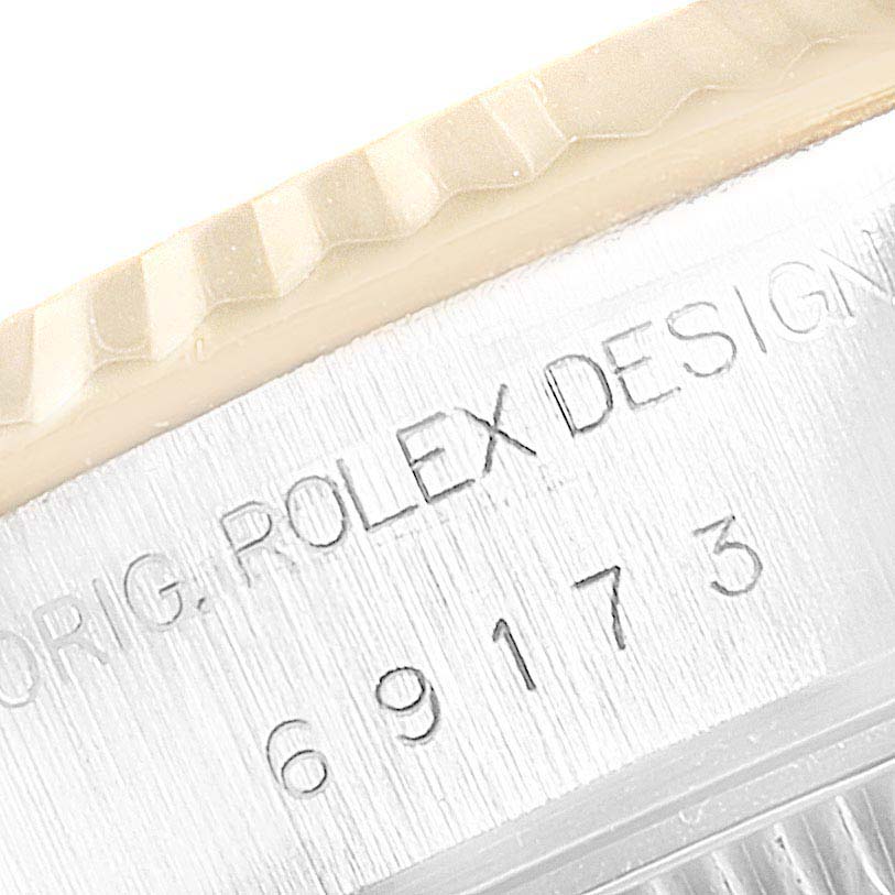 This image shows the engraved serial number and design details on the side of the Rolex Datejust 69173 Women's Steel and Gold (two tone) Beige Dial 69173 Women's Steel and Gold (two tone) Beige Dial watch case.